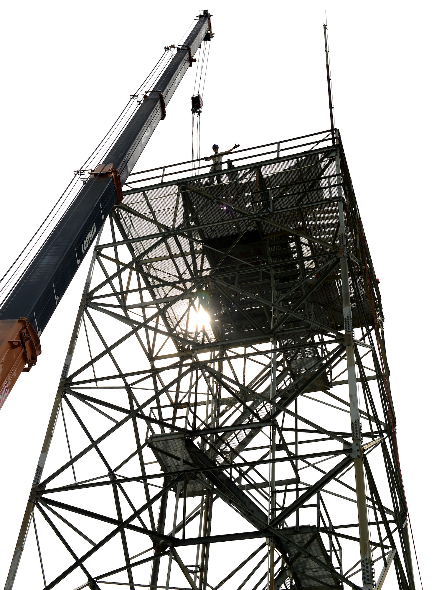 U.S. Air Force Tech. Sgt. Benjamin Rowley, Headquarters Air Force Flight Standards Agency-European Regional Maintenance Center radar systems NCO in charge, signals a crane operator during the removal of a Ground Pulse Navigation-20 Airport Surveillance Radar antenna, May 13, 2015, at Aviano Air Base, Italy. The team of radar systems technicians from Kapaun Air Station, Germany, worked with the 31st Operations Support Squadron ground radar maintenance flight and the Air Force Life Cycle Management Center from Hanscom Air Force Base, Mass., to remove the decommissioned antenna from a 77-foot tower. (U.S. Air Force photo by Staff Sgt. R.J. Biermann/Released)