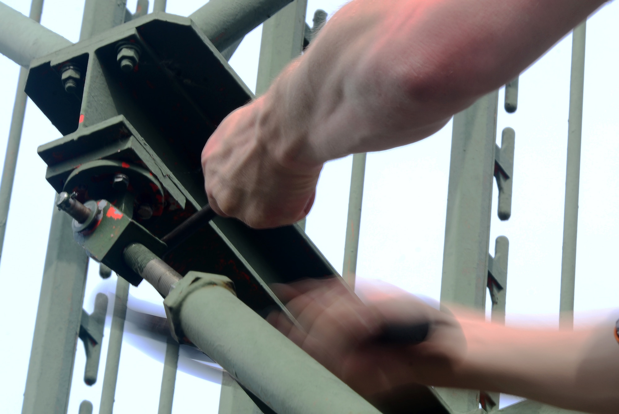 U.S. Air Force Tech. Sgt. Joseph McKeown, Headquarters Air Force Flight Standards Agency-European Regional Maintenance Center radar systems team lead, hammers out a linchpin from a support arm on a Ground Pulse Navigation-20 Airport Surveillance Radar antenna, May 13, 2015, at Aviano Air Base, Italy. The team of radar systems technicians from Kapaun Air Station, Germany, worked with the 31st Operations Support Squadron ground radar maintenance flight and the Air Force Life Cycle Management Center from Hanscom Air Force Base, Mass., to remove the decommissioned antenna from a 77-foot tower. (U.S. Air Force photo by Staff Sgt. R.J. Biermann/Released) 