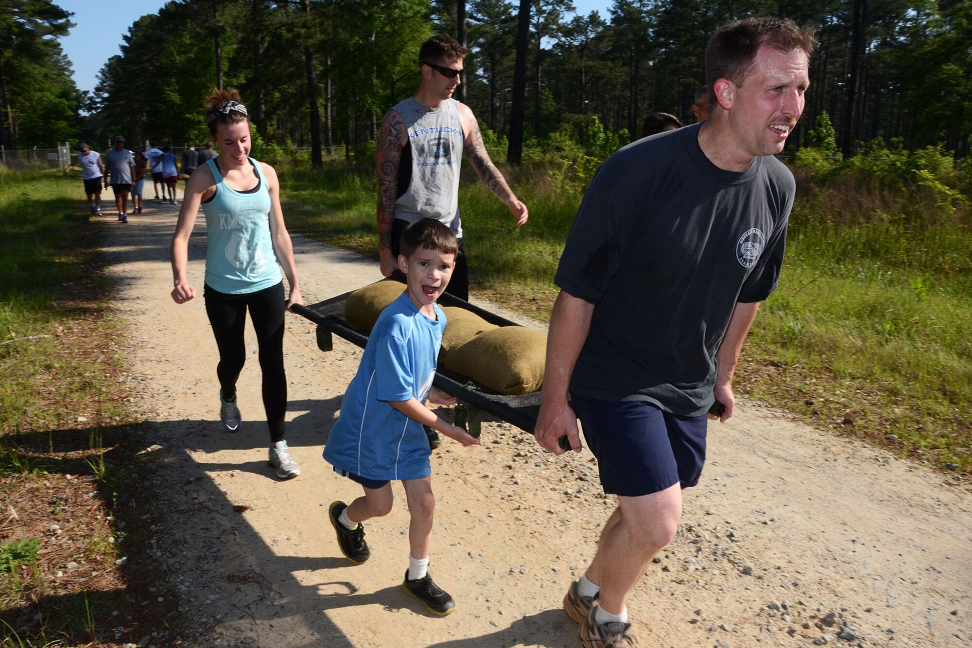 Airmen and their families from the 169th Fighter Wing and the South Carolina Air National Guard perform a litter carry exercise during the first ever Life of a Warrior Run at McEntire Joint National Guard Base, S.C., May 2, 2015.  The event was held to raise funds for the Warm Hearts Foundation which offers donations and grants to base families who are in need.  (U.S. Air National Guard photo by Amn Megan Floyd/Released)