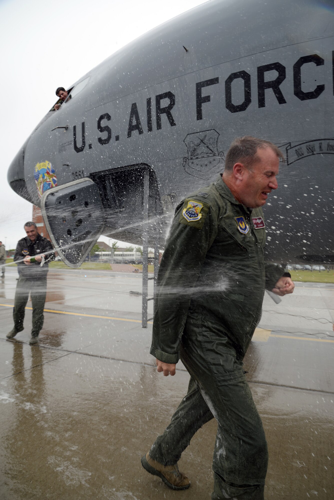 U.S. Air Force Col. Kenneth T. Bibb, Jr., 100th Air Refueling Wing commander, is sprayed with water from all directions as part of his “fini-flight” May 12, 2015, on RAF Mildenhall, England. Bibb’s family and other members of Team Mildenhall took turns dousing Bibb with water as part of “fini-flight” traditions commemorating his time as base commander. (U.S. Air Force photo by Senior Airman Kyla Gifford/Released)
