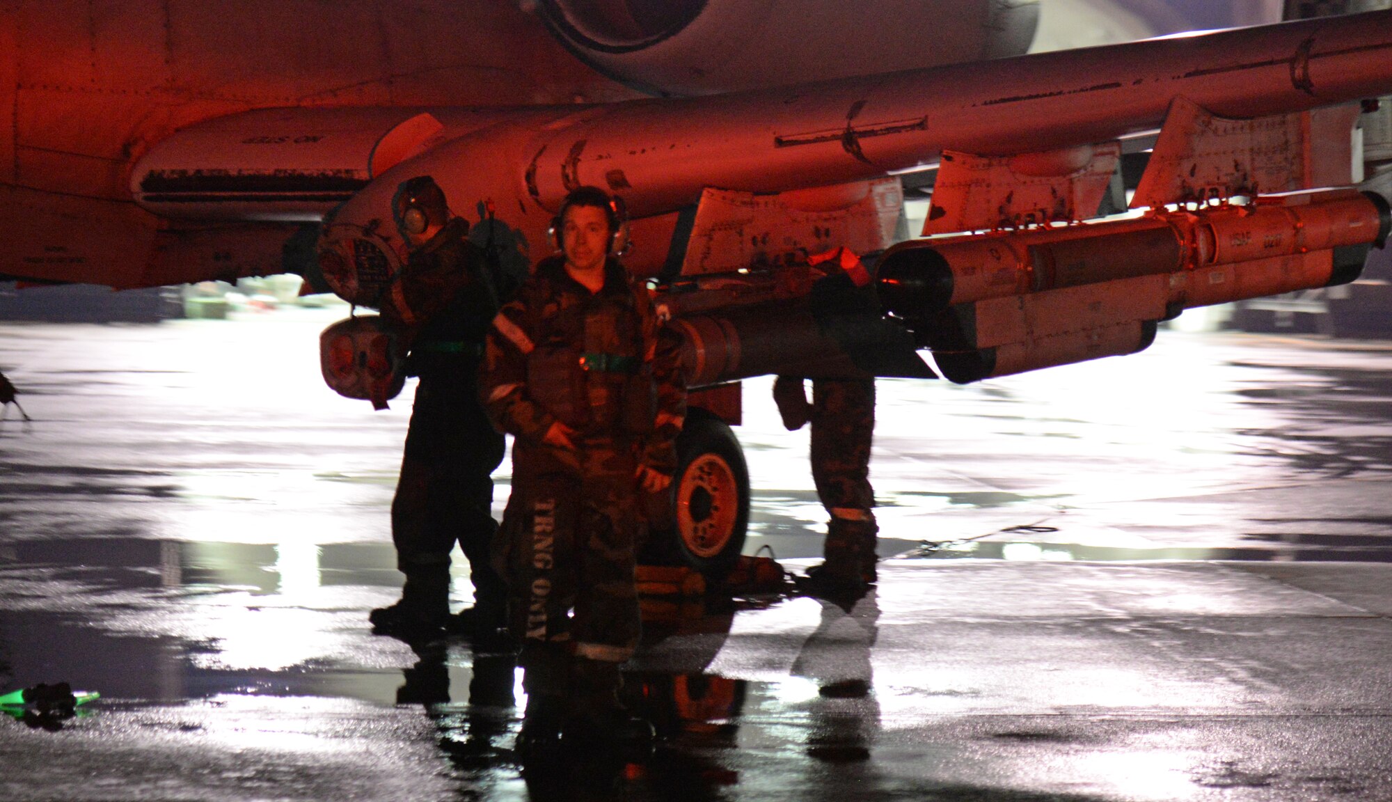 A member of Team Osan strikes a pose during his 12-hour shift May 12, 2015, at Osan Air Base, Korea. Despite monsoon-like conditions and wearing Mission Oriented Protective Posture gear, maintainers battled throughout the night to get aircraft in the skies for the combat exercise Beverly Midnight 15-02. The exercise tests American and ROK on  mission readiness in the event of an emergency or possible wartime combat environment. (U.S. Air Force photo by Staff Sgt. Benjamin Sutton/Released) 