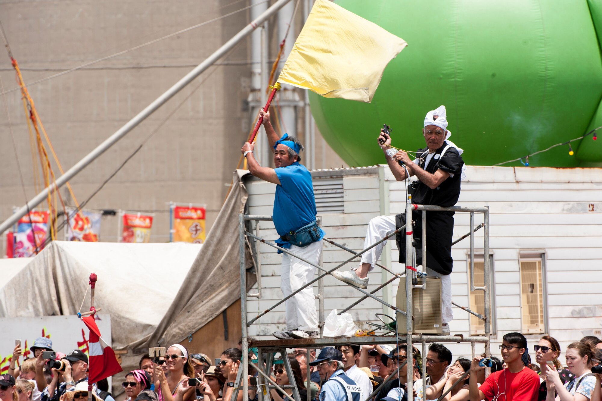 Spectators watch with anticipation as the flag is dropped, signaling the start of a heat during the Naha Dragon Boat Race at Naha Port, Japan, May 5, 2015. Months of hard work, long practices and extensive conditioning goes into competing for the Kadena Shoguns each year for the nearly three dozen members on each team. (U.S. Air Force photo by Senior Airman Omari Bernard) 