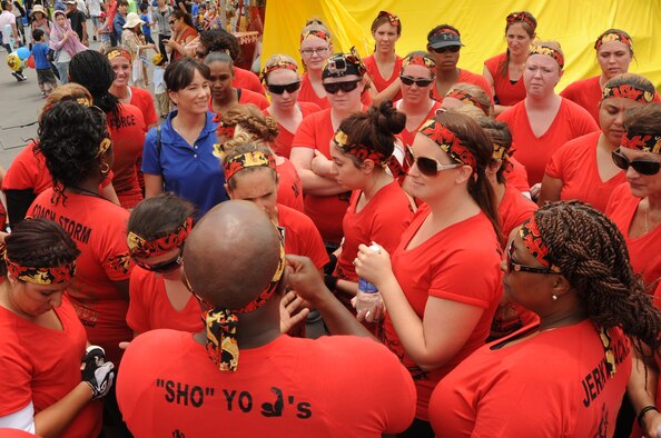 The Kadena Shogun women's dragon boat racing team huddles before their heat during the Naha Dragon Boat Race at Naha Port, Japan, May 5, 2015. The women's team finished in 11th place out of 63 other teams and came in third place in their heat. (U.S. Air Force photo by Senior Airman Omari Bernard)