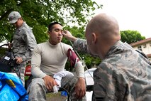 Staff Sgt. Benjamin Smith, right, 374th Aerospace Medicine Squadron NCO in charge of the flight medicine clinic, takes vitals from Senior Airman Vonfernan Carios, 374 AMDS bioenvironmental engineering technician, May 6, 2015, at Yokota Air Base, Japan. Emergency responders were examined after performing under potentially stressful and harmful conditions at the scene of a mock environmental hazard. (U.S. Air Force photo by Airman 1st Class Elizabeth Baker/Released)