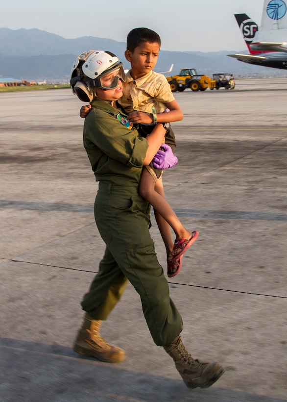 U.S. Marine Corps Sgt. A.B. Manning carries a young earthquake victim to a medical triage area at Tribhuvan International Airport in Kathmandu, Nepal, May 12, 2015. 