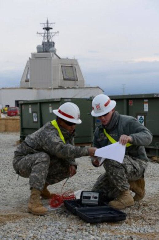 Sgt. Win Htun, left, and Sgt. Corey Good look over instructions before testing for electrical ground at Naval Support Facility Deveselu, Romania, April 19, 2015. Htun, from New York, and Good, from Moline, Ill., are assigned to the 249th Engineer...