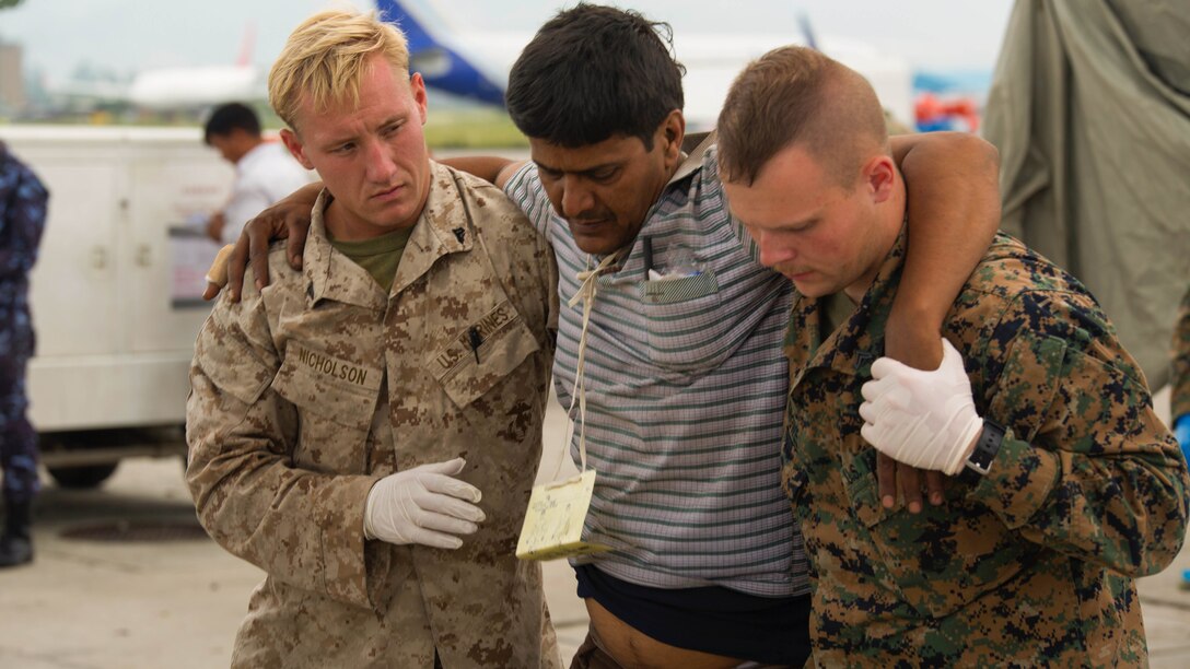 U.S. Marines help a Nepalese man to a triage at the Tribhuvan International Airport in Kathmandu, Nepal, May 13. Joint Task Force 505 service members are in Nepal conducting earthquake recovery operations as part of Operation Sahayogi Haat. A 7.3 magnitude earthquake shook the country May 12, nearly two weeks after a larger earthquake struck April 25.