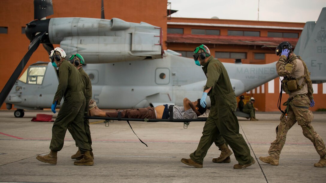 A U.S. Air Force pararescueman directs U.S. Marines carrying a Nepalese man to a triage at the Tribhuvan International Airport in Kathmandu, Nepal, May 13. Joint Task Force 505 service members are in Nepal conducting earthquake recovery operations as part of Operation Sahayogi Haat. A 7.3 magnitude earthquake shook the country May 12, nearly two weeks after a larger earthquake struck April 25. 