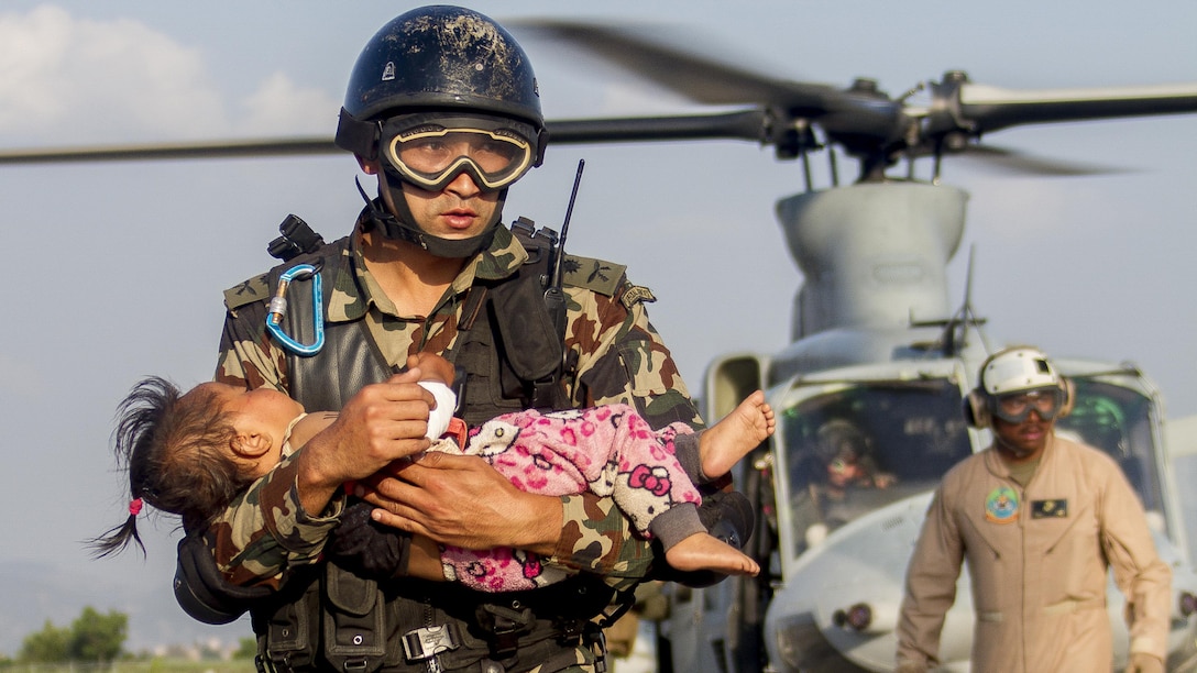 A Nepalese soldier carries a young earthquake victim from a U.S. Marine Corps UH-1Y Venom helicopter assigned to Joint Task Force 505 to a medical triage area at Tribhuvan International Airport, Kathmandu, Nepal, after a 7.3 magnitude earthquake struck the country, May 12. Joint Task Force 505 along with other multinational forces and humanitarian relief organizations are currently in the Nepal providing aid after a 7.8 magnitude earthquake struck the country, April 25. At Nepal’s request the U.S. government ordered JTF 505 to provide unique capabilities to assist Nepal. (U.S. Marine Corps photo by Gunnery Sgt. Ricardo Morales/Released)