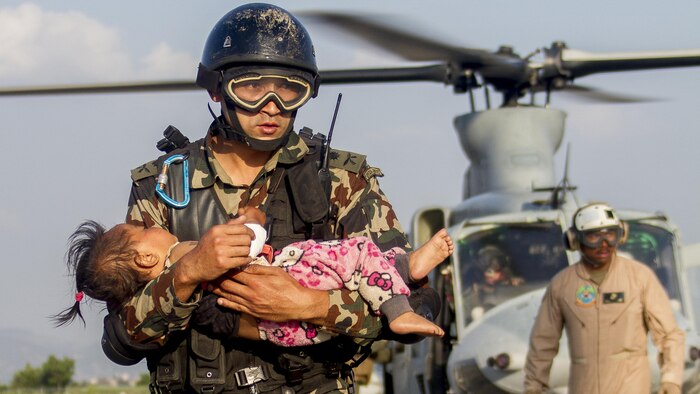 A Nepalese soldier carries a young earthquake victim from a U.S. Marine Corps UH-1Y Venom helicopter assigned to Joint Task Force 505 to a medical triage area at Tribhuvan International Airport, Kathmandu, Nepal, after a 7.3 magnitude earthquake struck the country, May 12. Joint Task Force 505 along with other multinational forces and humanitarian relief organizations are currently in the Nepal providing aid after a 7.8 magnitude earthquake struck the country, April 25. At Nepal’s request the U.S. government ordered JTF 505 to provide unique capabilities to assist Nepal. (U.S. Marine Corps photo by Gunnery Sgt. Ricardo Morales/Released)