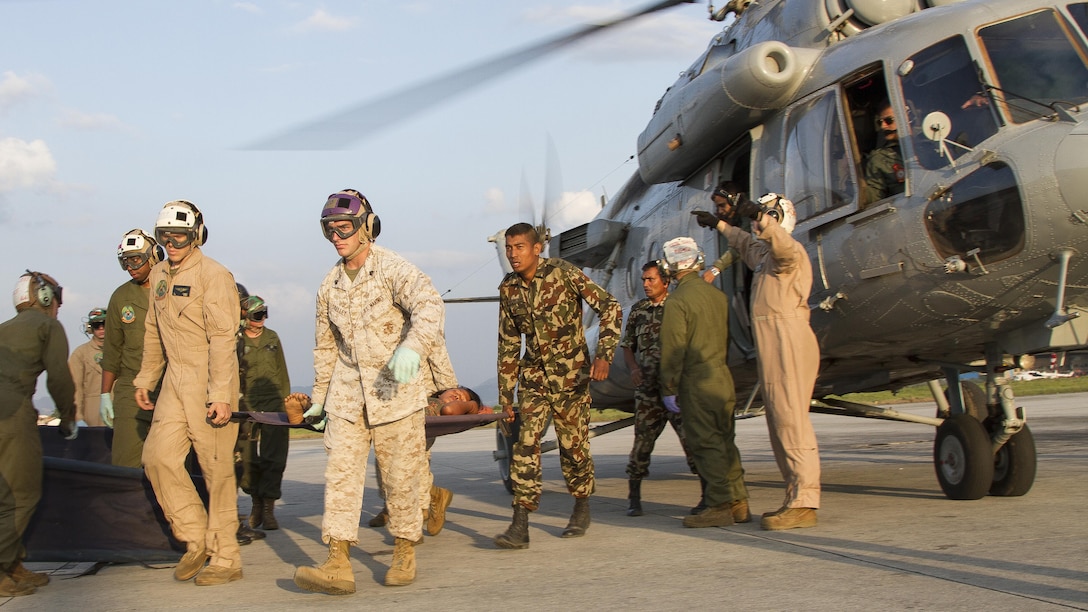 U.S. service members from Joint Task Force 505 and Nepalese soldiers unload casualties from an Indian military helicopter at Tribhuvan International Airport, Kathmandu, Nepal, after a 7.3 magnitude earthquake struck the country, May 12. Joint Task Force 505 along with other multinational forces and humanitarian relief organizations are currently in the Nepal providing aid after a 7.8 magnitude earthquake struck the country, April 25. At Nepal’s request the U.S. government ordered JTF 505 to provide unique capabilities to assist Nepal. (U.S. Marine Corps photo by Gunnery Sgt. Ricardo Morales/Released)