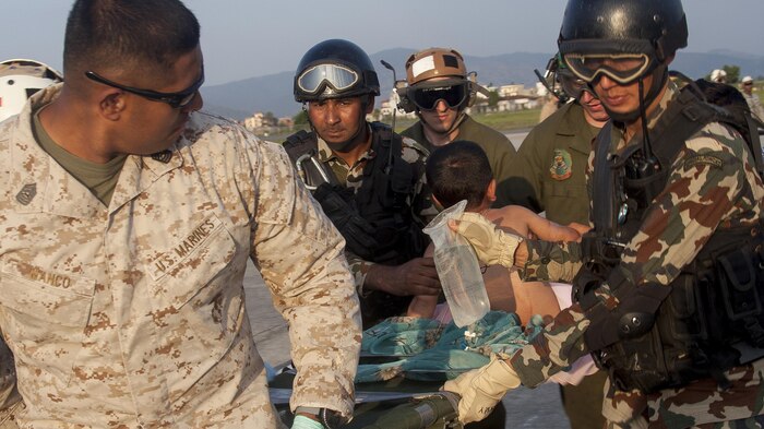 U.S. service members from Joint Task Force 505 and Nepalese soldiers unload casualties to a medical triage area at Tribhuvan International Airport, Kathmandu, Nepal, after a 7.3 magnitude earthquake struck the country, May 12. Joint Task Force 505 along with other multinational forces and humanitarian relief organizations are currently in the Nepal providing aid after a 7.8 magnitude earthquake struck the country, April 25. At Nepal’s request the U.S. government ordered JTF 505 to provide unique capabilities to assist Nepal. (U.S. Marine Corps photo by Gunnery Sgt. Ricardo Morales/Released)