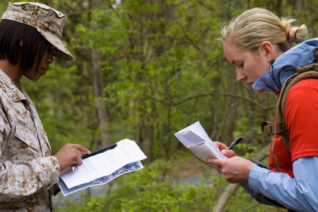 U.S. Marine Corps Marine Corps Capt. Lisa Lawrence-Arocho, an officer selection officer for Recruiting Station Baltimore, dictates an operations order to officer candidate Sara Walker, a graduate of Saint Joseph’s University, during a training exercise at the Naval Support Activity Annapolis, Maryland, April 25, 2015. The exercise was designed to prepare officer candidates from Recruiting Stations Baltimore and Frederick for the physical and mental challenges of Marine Corps Officer Candidate School. OCS trains, screens and evaluates candidates, who must demonstrate a high level of leadership potential and commitment to success in order to earn a commission as an officer in the United States Marine Corps. (U.S. Marine Corps photo by Sgt. Bryan Nygaard/Released)