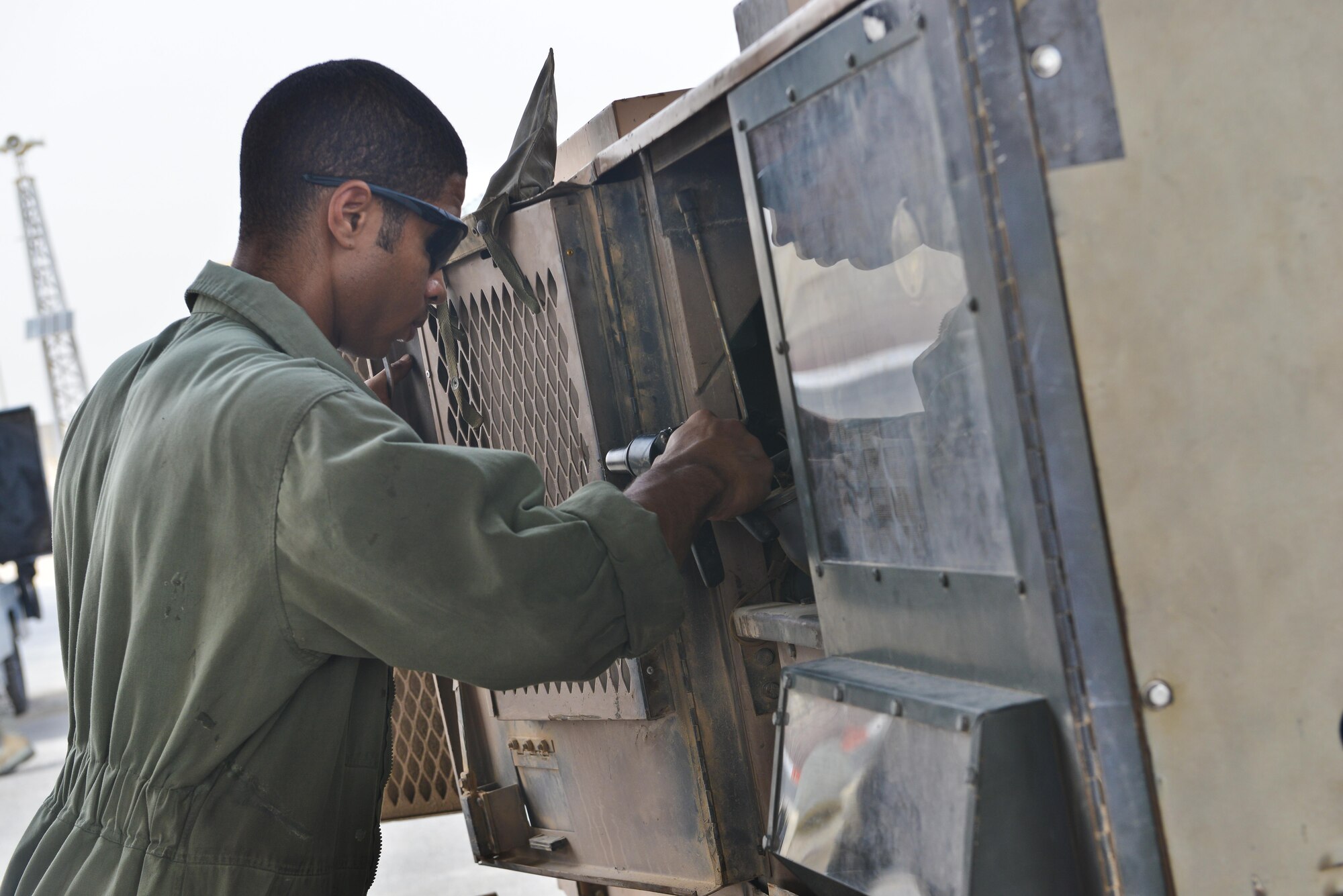 Senior Airman Udoka Addy, 379th Expeditionary Maintenance Squadron, applies rivets to a generator door during routine aerospace ground equipment repairs May 7, 2015 at Al Udeid Air Base, Qatar. Aircraft Ground Equipment airmen rotate shifts to ensure day and night operations are supplied with functioning equipment. These airmen endure heat that sometimes reaches above 100 degrees Fahrenheit causing them to sometimes work in black flag conditions. (U.S. Air Force photo by Staff Sgt. Alexandre Montes)  