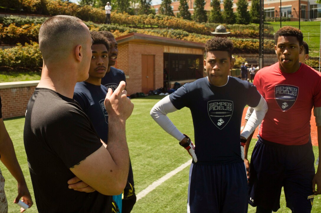 Marine Corps Sgt. Michael Reyes, a recruiter for Marine Corps Recruiting Station Baltimore, gives high school athletes a few pointers about running receiving routes during the Marine Corps’ Semper Fidelis All-American Football Camp, which was held at St. John’s College High School in Washington DC on April 26, 2015.  The Semper Fidelis All-American Football Camp allowed student athletes to hone their football skills while receiving instruction from high school, college and NFL Players Association Coaches. In addition, these students had the distinct opportunity of receiving discipline, leadership and character skills from United States Marines. (US Marine Corps photo by Sgt. Bryan Nygaard/Released)