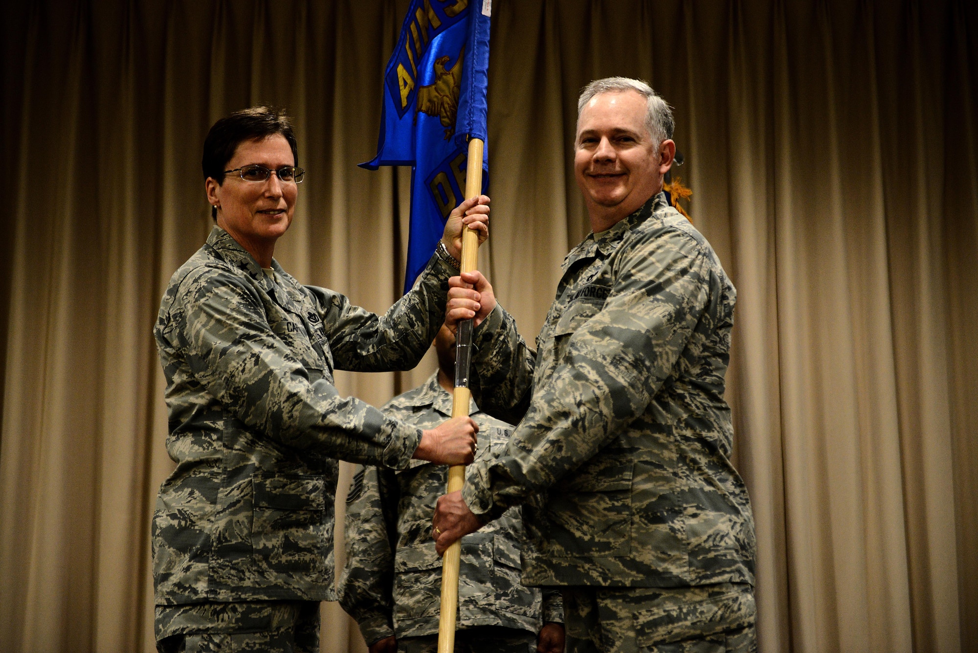 Maj. Gen. Theresa Carter, Air Force Installation and Mission Support Center commander, passes the AFIMSC Detachment 9 flag to Col. Mark McCloud, AFIMSC Det. 9 commander, May 7 at Headquarters Air Mobility Command Airlifters' Hall, Scott Air Force Base, Ill. AFIMSC consolidates installation management functions currently being performed at every major command and will serve as the single intermediate-level headquarters for the delivery of installation support capabilities.(U.S. Air Force photo/Senior Airman Jake Eckhardt/Released)