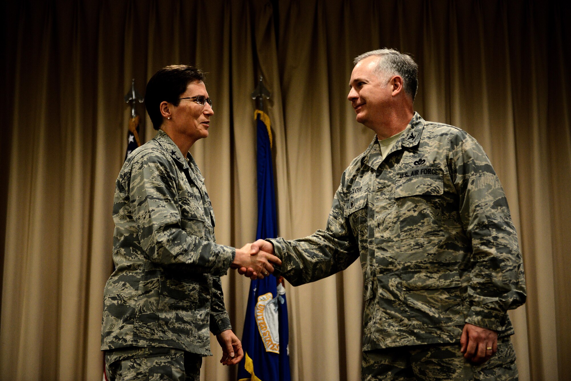 Maj. Gen. Theresa Carter, Air Force Installation and Mission Support Center commander, shakes hands with Col. Mark McCloud, the newly appointed AFIMSC Detachment 9 commander, May 7 at Headquarters Air Mobility Command Airlifters' Hall, Scott Air Force Base, Ill. AFIMSC consolidates installation management functions currently being performed at every major command and will serve as the single intermediate-level headquarters for the delivery of installation support capabilities.(U.S. Air Force photo/Senior Airman Jake Eckhardt/Released)