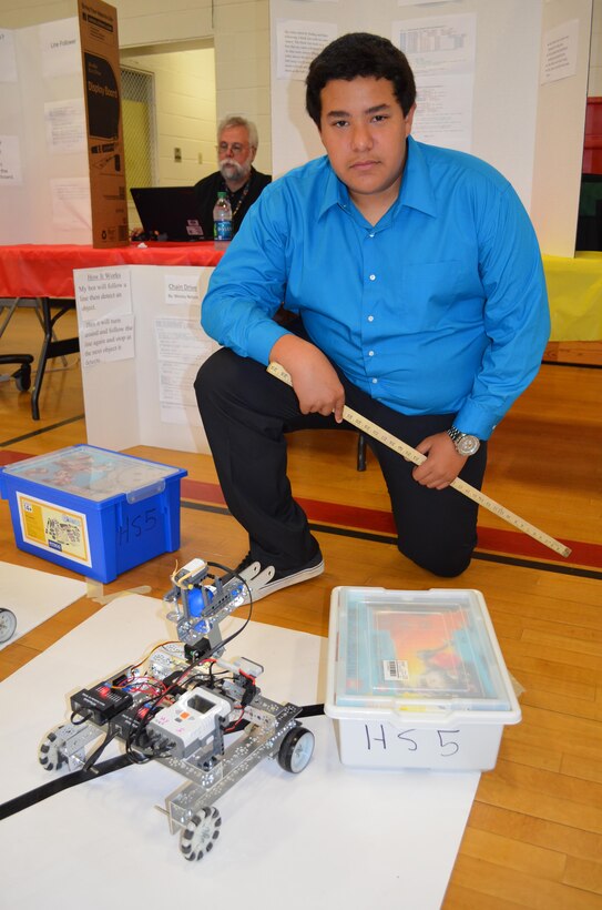 Daymon, 16, poses with his robot after demonstrating its abilities during the April 30 STEMposium, an event at Quantico Middle/High School.