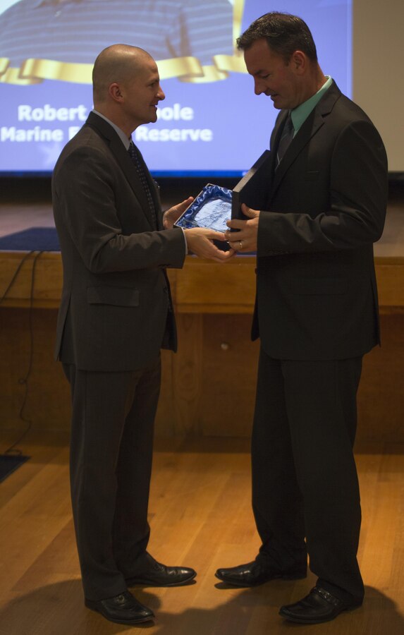 Robert J. O’Toole (right), the Supervisor of Human Resources with Marine Forces Reserve, is presented the Federal Supervisor award during Public Service Recognition Week at the University of New Orleans, May 13, 2015.  Once a year, the New Orleans Federal Executive Board hosts a ceremony to present military personnel, state and federal government employees with awards that recognize their hard work and dedication to public service. 