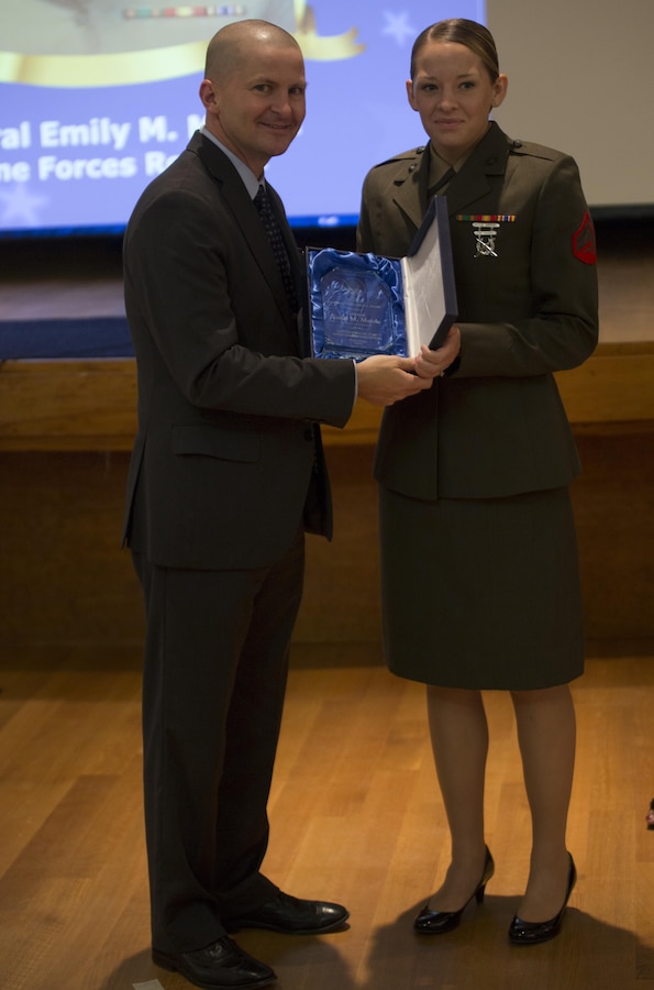 Cpl. Emily M. Massia (right), administrative clerk with Marine Forces Reserve is presented the Outstanding Military Noncommissioned Officer award during Public Service Recognition Week at the University of New Orleans, May 13, 2015. Once a year, the New Orleans Federal Executive Board hosts a ceremony to present military personnel, state and federal government employees with awards that recognize their hard work and dedication to public service.