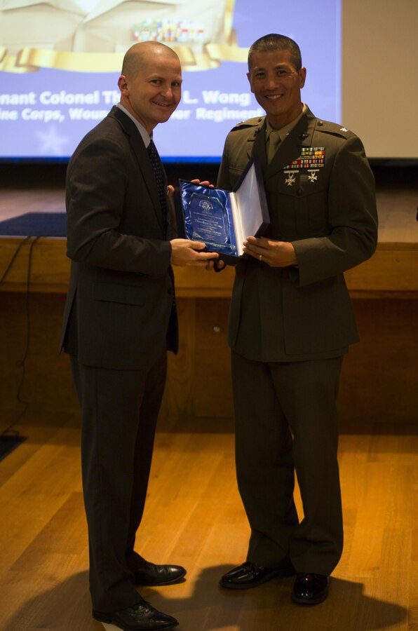 Lt. Col. Theodore L. Wong (right), the Wounded Warrior Regiment Marine Forces Reserve Liaison Officer, is presented the Outstanding Military Field Grade Officer award during Public Service Recognition Week at the University of New Orleans, May 13, 2015. Once a year, the New Orleans Federal Executive Board hosts a ceremony to present military personnel, state and federal government employees with awards that recognize their hard work and dedication to public service. 