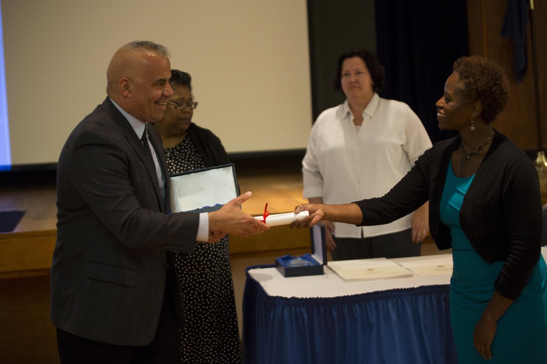 Oscar W. Stewart (left), Marine Air-Ground Task Force Information Technology Support Center Reserve Desk Manager with Marine Forces Reserve, is presented the Outstanding Individual Customer Service Effort award during Public Service Recognition Week at the University of New Orleans, May 13, 2015.  Once a year, the New Orleans Federal Executive Board hosts a ceremony to present military personnel, state and federal government employees with awards that recognize their hard work and dedication to public service. 