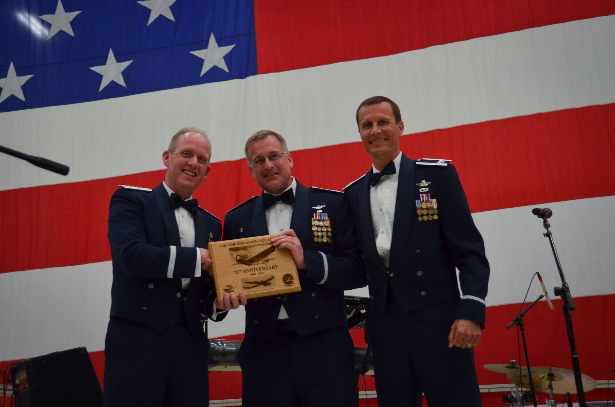 Maj. Gen. Donald Dunbar, the Adjutant General of Wisconsin, and Col. Chad Milne, the Wisconsin Air National Guard State Director of Operations, presented an honorary plaque to Col. Steven Hunter, the 126th Air Refueling Squadron commander, commemorating the 75th year anniversary of the aviation squadron at the 35th annual Civic Dinner Dance in the aircraft hangar here May 14, 2015.  The Civic Dinner Dance is an event coordinated by the Milwaukee Armed Forces Committee for Wisconsin military members, elected state and local officials, and citizens of the local Milwaukee area to celebrate community relations during Armed Forces Week.  (U.S. Air National Guard photo by Tech. Sgt. Jenna Lenski/Released)