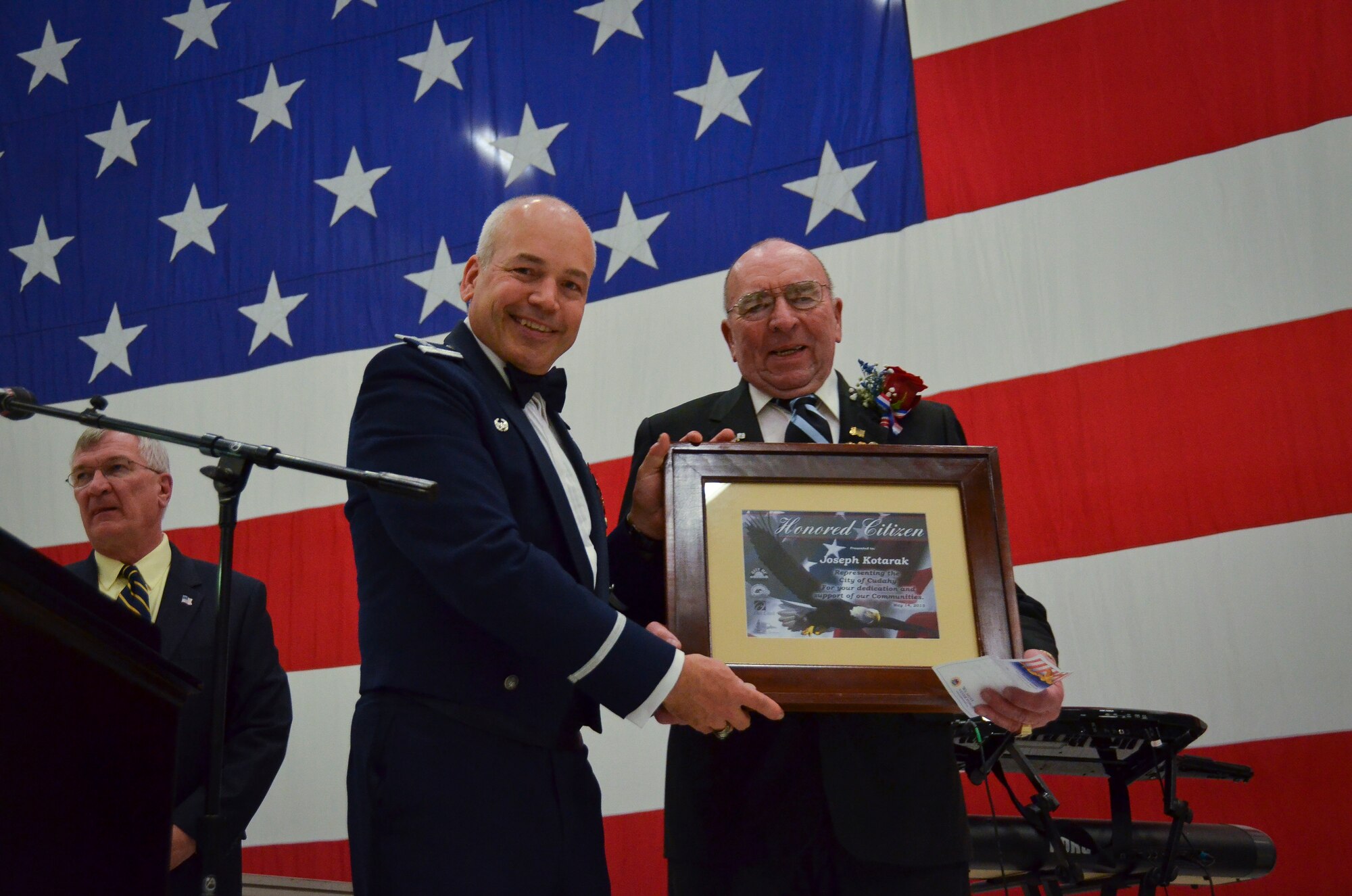 Col. Daniel Yenchesky, the 128th Air Refueling Wing commander, presents the Honored Citizen Award to Joseph Kotarak, Jr. at the 35th annual Civic Dinner Dance in the aircraft hangar here May 14, 2015.  The Civic Dinner Dance is an event coordinated by the Milwaukee Armed Forces Committee for Wisconsin military members, elected state and local officials, and citizens of the local Milwaukee area to celebrate community relations during Armed Forces Week.  (U.S. Air National Guard photo by Tech. Sgt. Jenna Lenski/Released)
