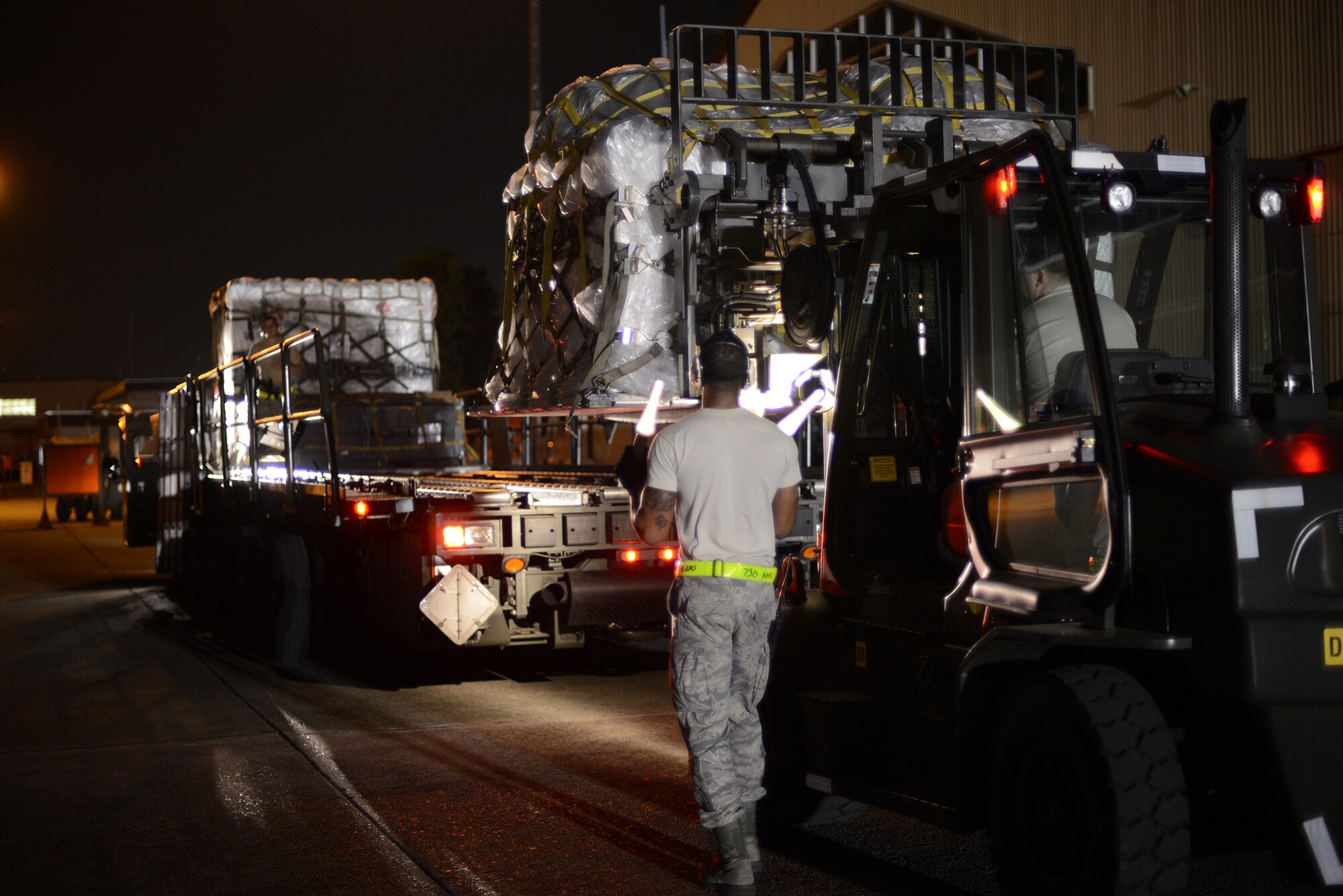 An Airman from the 730th Air Mobility Squadron marshals a forklift during a Samurai Readiness Inspection at Yokota Air Base, Japan, May 14, 2015. The inspection tested Yokota's ability to receive and deploy forces and equipment during contingency operations. (U.S. Air Force photo by Airman 1st Class David C. Danford/Released)