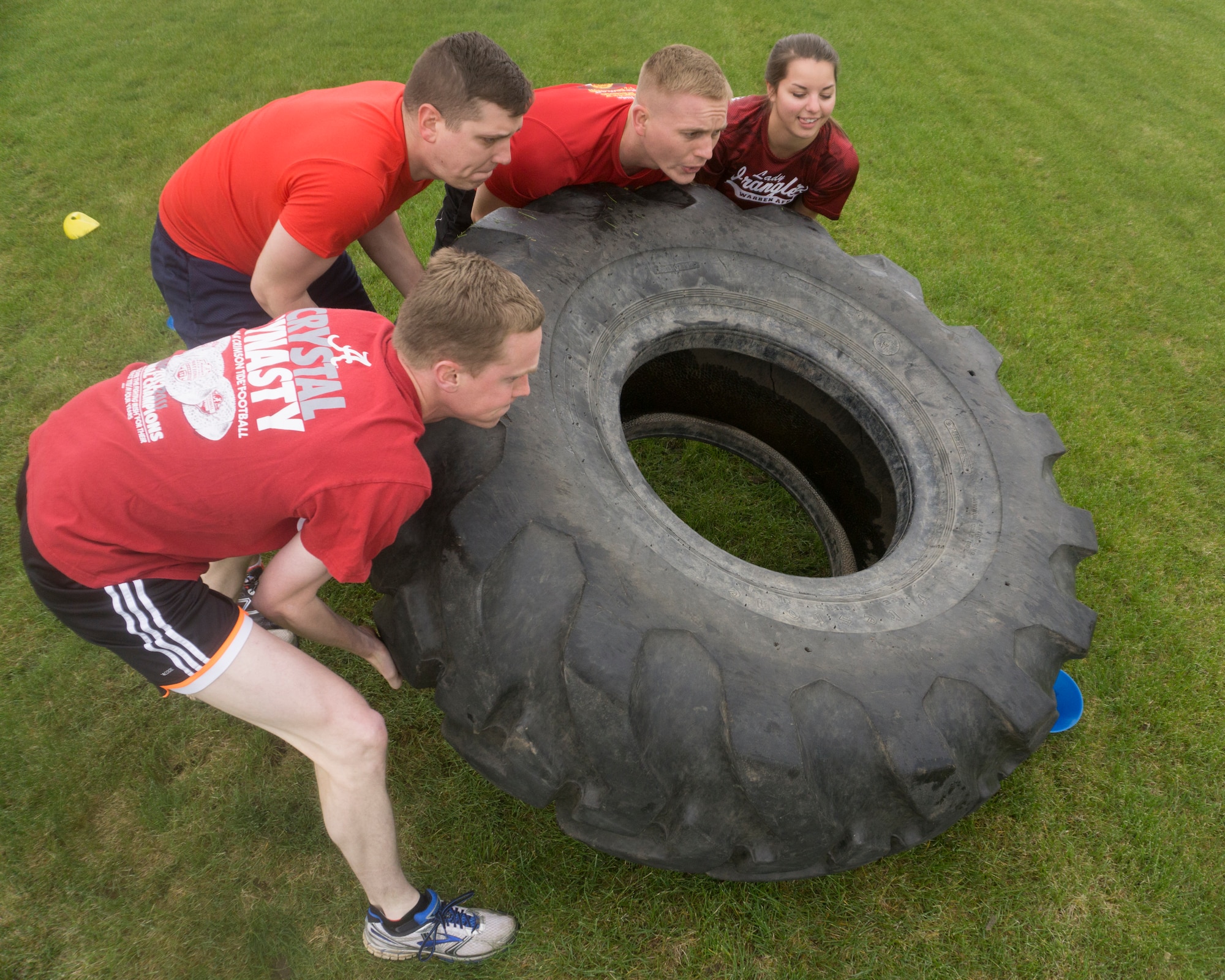 First  Lt. Charles Berry, Capts. Daniel Holley and Jonathan Dial, and Airman 1st Class Abbie LaPointe, 90th Missile Wing Judge Advocate, lift a 500-pound tire during the team torture event May 13, 2015, on F.E. Warren Air Force Base, Wyo. The event included a 50-yard tire flip, 50-yard log carry, 50-yard body drag, and a 50-yard relay.   (U.S. Air Force Photo by Lan Kim)
