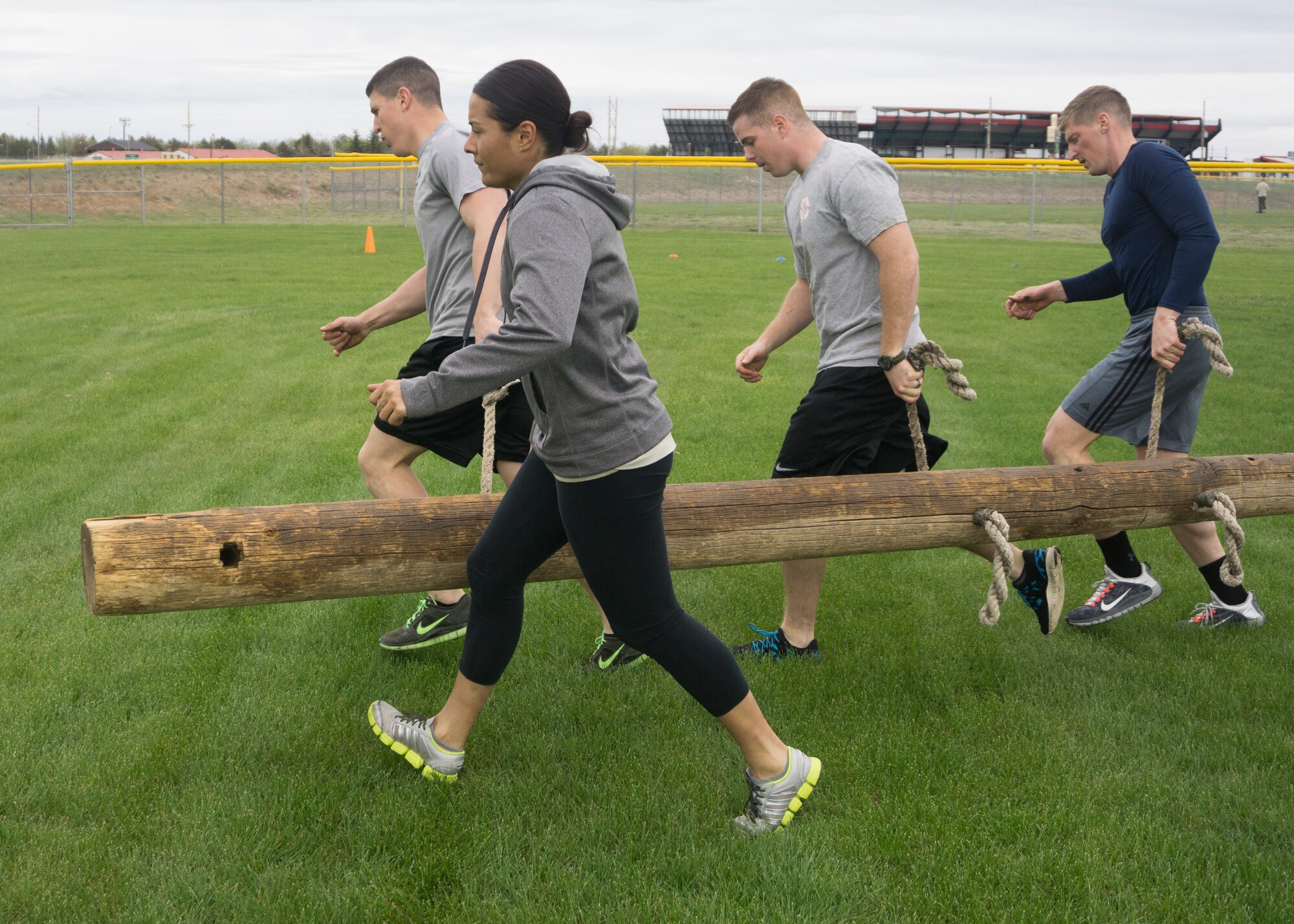 Senior Airman Ben Davis, Staff Sgts. Michelle Velazco, Nick Howard, and Daniel Hadley, 90th Security Forces Group Tactical Response Force, perform the 50-yard log carry during the team torture event. The TRF team won the overall event with a total time of 3 minutes and 29 seconds.  (U.S. Air Force Photo by Lan Kim)
