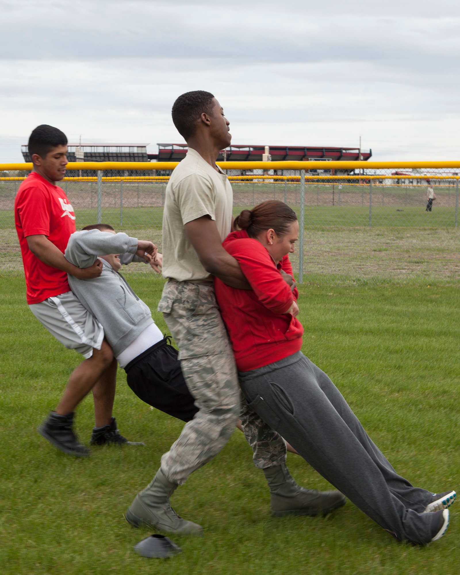 Airman 1st Class Ozzie Galvan, Staff Sgt. Kevin Pordon, Senior Airman Ben Cole, and Senior Airman Summer Mathews, 90th Force Support Squadron, perform the 50-yard body drag portion of the team torture event May 13, 2015, on F.E. Warren Air Force Base. The event also included a 50-yard tire flip, 50-yard log carry, and a 50-yard relay. (U.S. Air Force Photo by Lan Kim)
