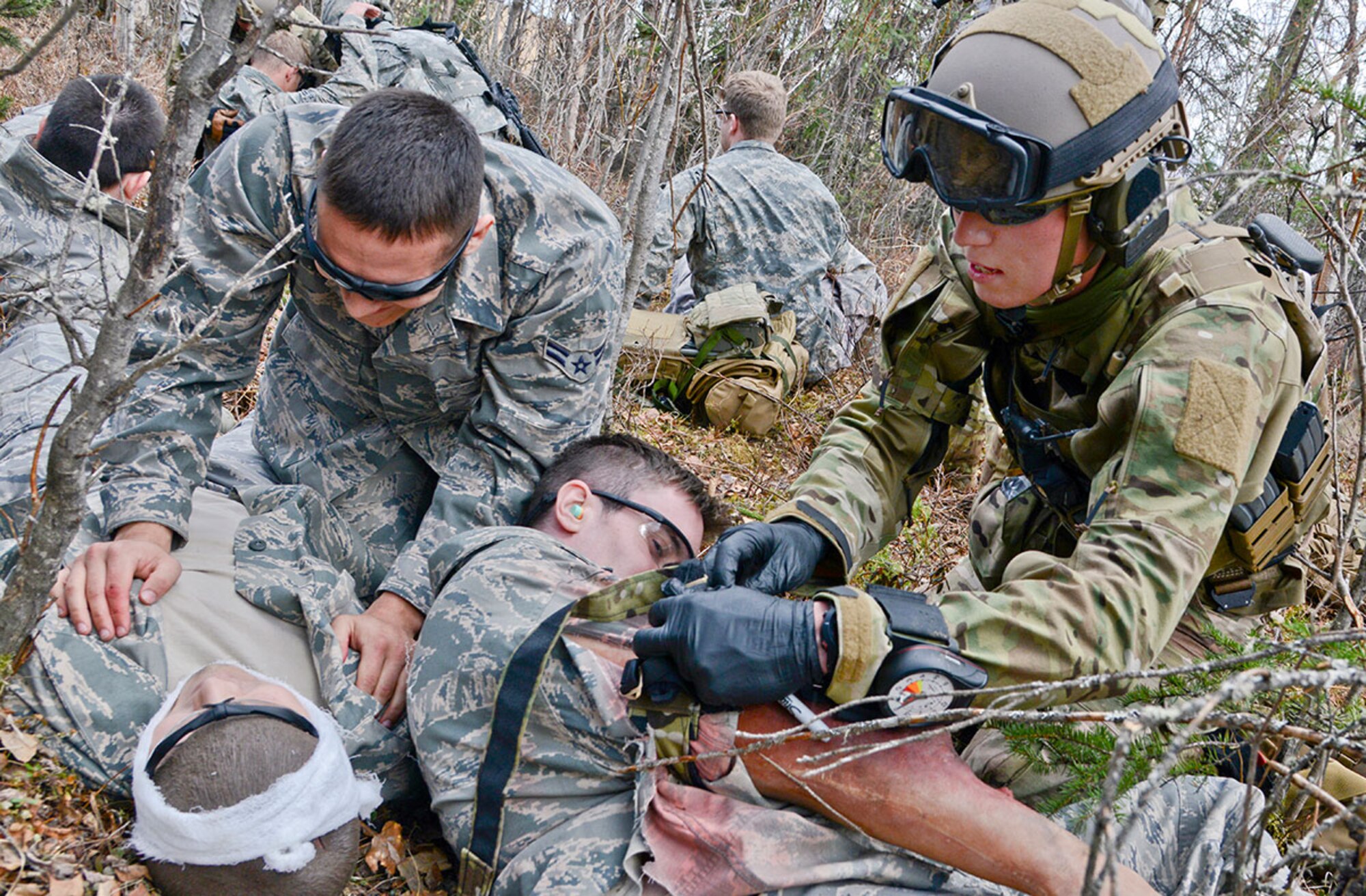 An Air Force pararescueman treats a wounded patient at a casualty collection point during an exercise at Joint Base Elmendorf-Richardson, Alaska, April 30. Army soldiers and PJs worked together in the exercise designed to integrate Army and Air Force combat casualty care capabilities. (U.S. Air Force photo/Staff Sgt. Wes Wright)