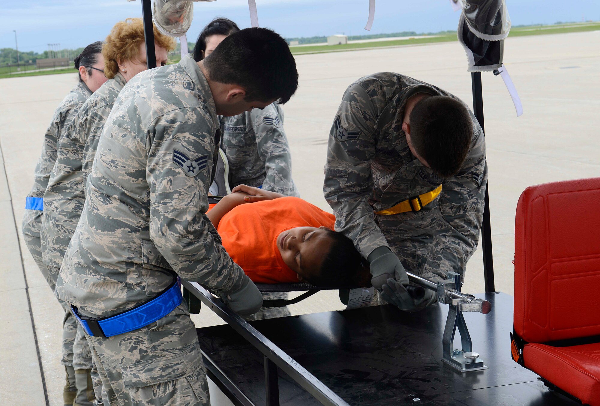 Members of the 22nd Medical Group transport a patient to a simulated triage tent, May, 13, 2015, at McConnell Air Force Base, Kan. The 22nd MDG participated in a training exercise, alongside the Robert J. Dole Veterans Affairs Medical Center and representatives from local hospitals. The training prepared the agencies to respond in the event a disaster struck an area and patients had to be transported here for care. (U.S. Air Force photo by Senior Airman Trevor Rhynes)
