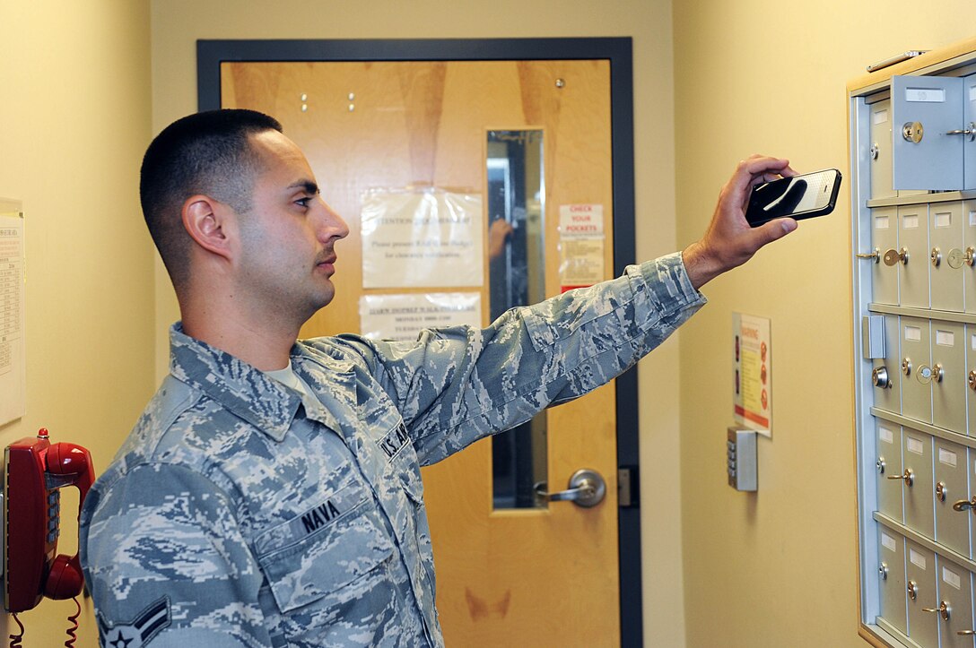 Airman 1st Class Emmanuel Nava, 22nd Operations Support Squadron operations intelligence analyst, puts his cell phone in a locker before entering the intelligence room, May 12, 2015, at McConnell Air Force Base, Kan. The two main priorities for the intelligence flight here are to support aircraft and aircrew and by providing the ‘ground truth’ to decision makers. (U.S. Air Force photo by Senior Airman David Bernal Del Agua)