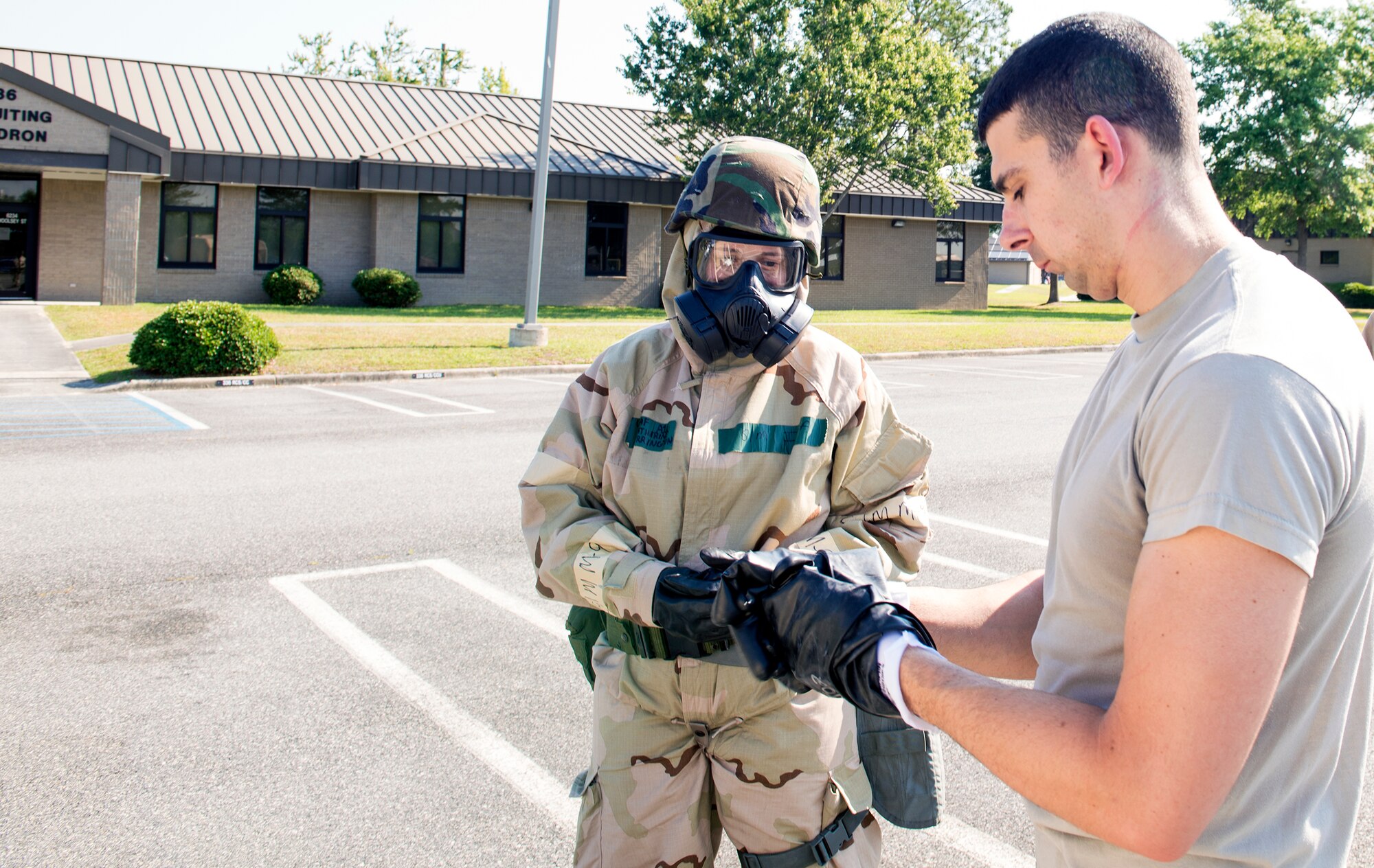 U.S. Air Force Capt. Michael Veltman, 347th Operations Support Squadron flight commander, removes gloves during an Aircrew Contamination Control Area decontamination training line May, 8, 2015, at Moody Air Force Base, Ga. This signifies that the decontamination procedure was successful after the shower zone, where no contaminants were identified. (U.S. Air Force photo by Airman Greg Nash/Released) 