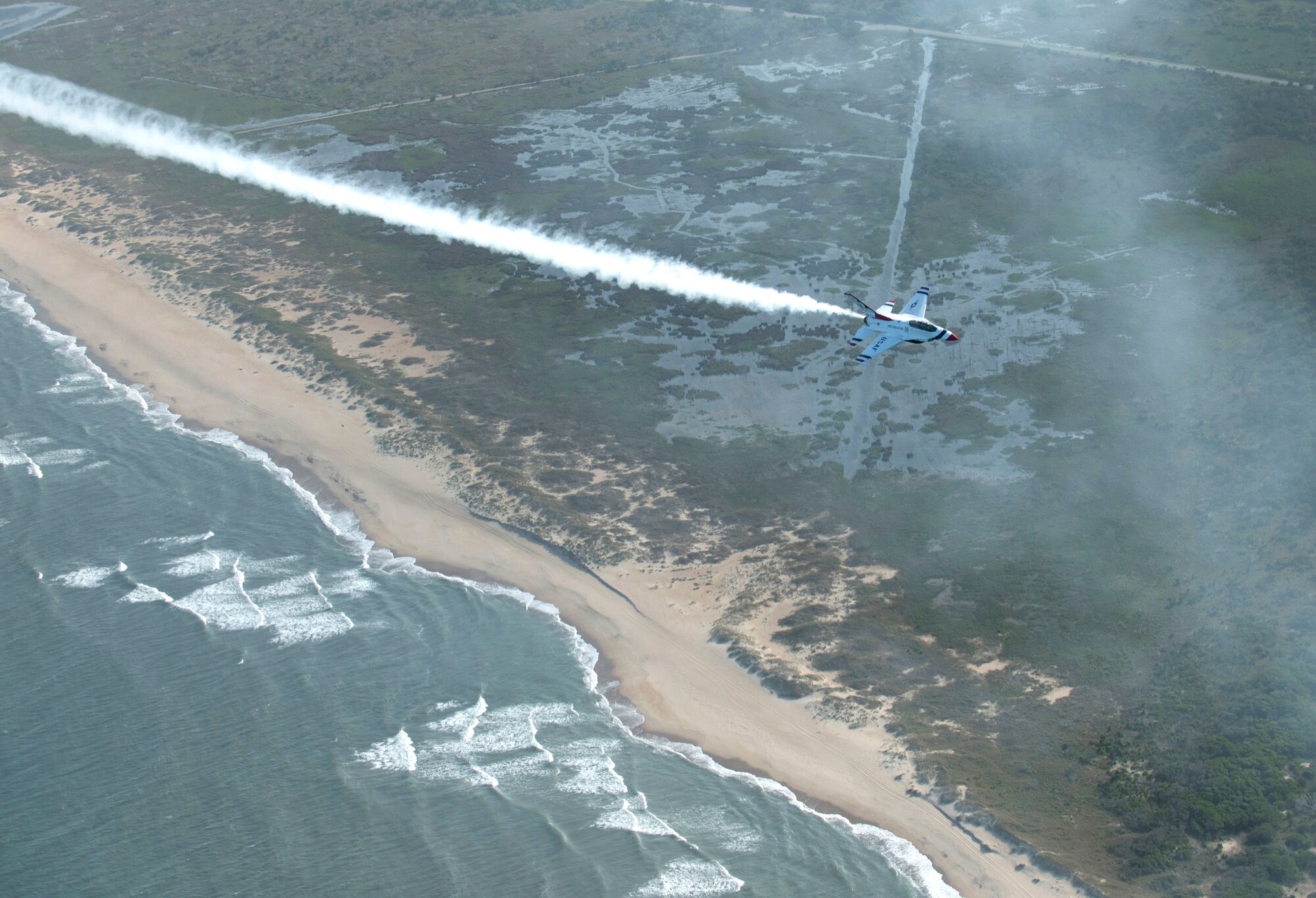 An F-16 Fighting Falcon with the U.S. Air Force Thunderbirds aerial demonstration team flies over the North Carolina Outer Banks , May 12, 2015. Along with the Thunderbirds and other performers, the 2015 Wings Over Wayne Airshow and Open House at Seymour Johnson Air Force Base, N.C., will highlight the prowess of the U.S. Army Black Daggers parachute demonstration team and the “Tora, Tora, Tora!” Pearl Harbor reenactment, and feature opportunities for up-close looks at static displays and ground demonstrations. (U.S. Air Force photo/Master Sgt. Jocelyn L. Rich-Pendracki) 