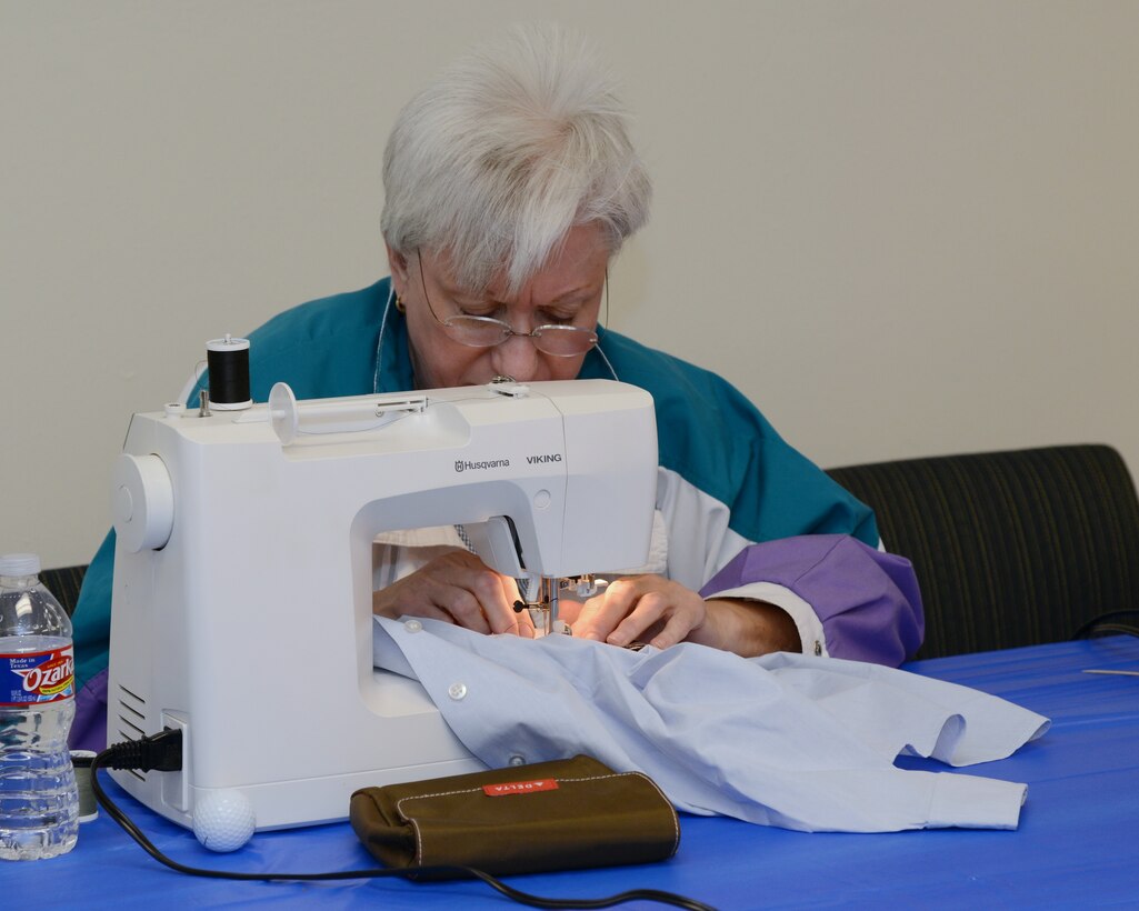 A volunteer add stripes to a uniform during the Gravity's monthly Supper and Stripes event. (Photo by Jamie Burnett)