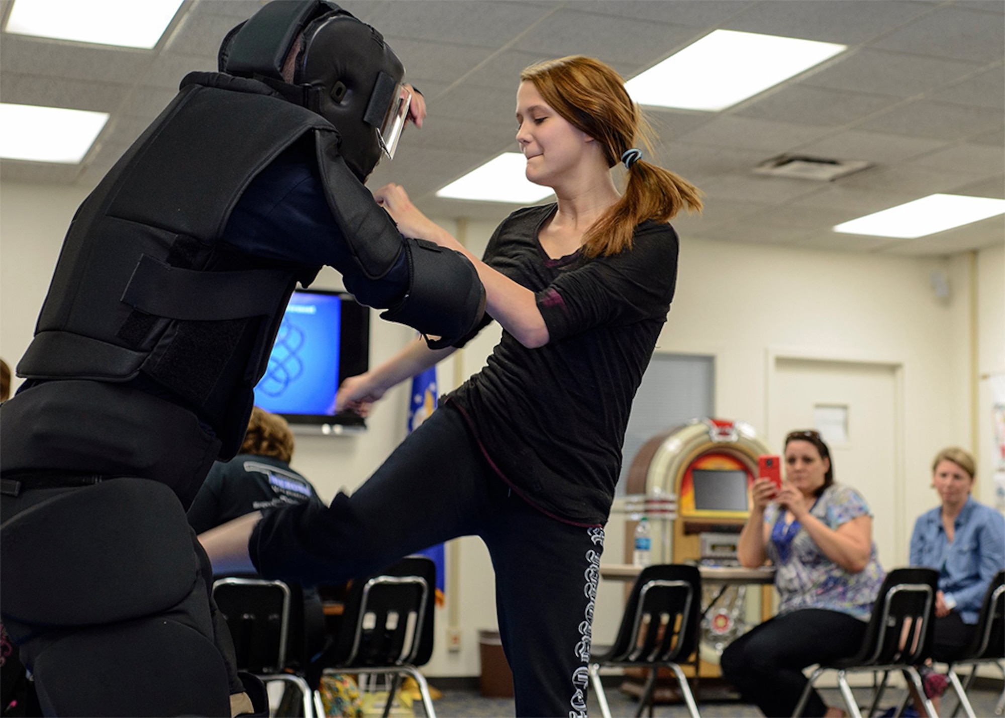 Camy Shearon fights off a suited instructor during an installment of "My Body... My Life…" at the Community Chapel Activity Center at Vance Air Force Base, Oklahoma, April 28. The course is designed to empower women "through awareness, education, violence prevention, and self-defense techniques." (U.S. Air Force photo / David Poe)
