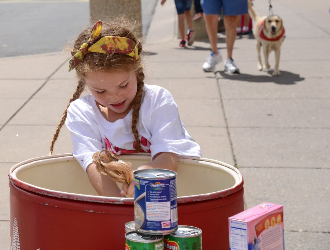 Andrea Rector, one of the volunteers from the Youth Center’s Helping Hands Club, solicits donations for Roadrunner Food Bank at the Commissary on May 6. (Photo by Jamie Burnett)