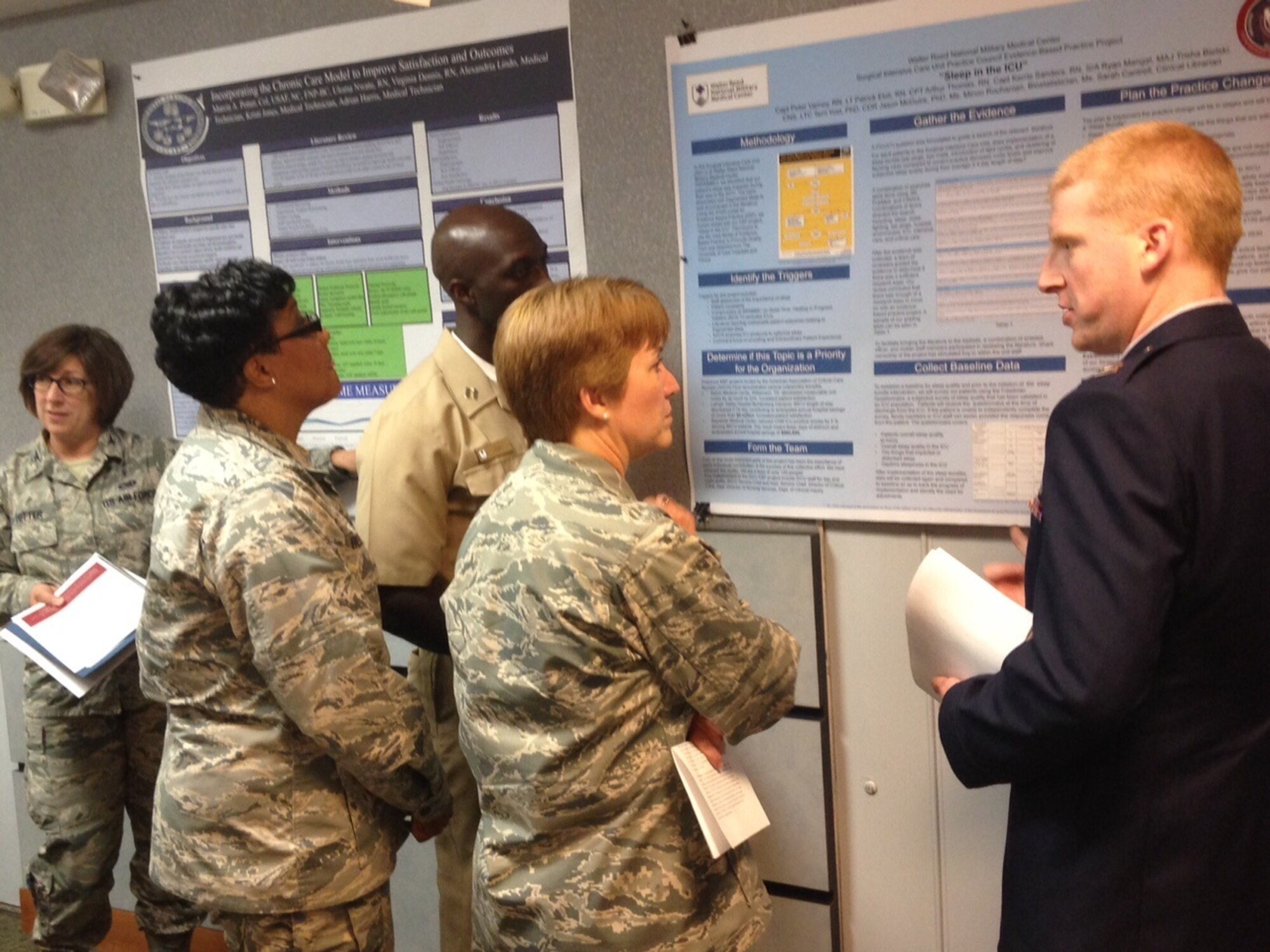 Major General Dorothy A. Hogg, Chief of the Air Force Nurse Corps, was the
keynote speaker at the 779th Medical Group's Knowledge Market on May 14,
2015 to celebrate Nurses and Medical Technician Week. The Knowledge
Market fair is a research and evidence based practice fair for nurses that allows them the opportunity to discuss advances in the field of nursing.  One of the presenters,
Captain Peter Varney, talks with Colonel Yolanda Bledsoe,
79th Medical Wing Chief Nurse and Maj. Gen. Hogg at the event about his project on "Sleep in the ICU". (AF Photo by Melanie Moore, Public Affairs Officer.)
