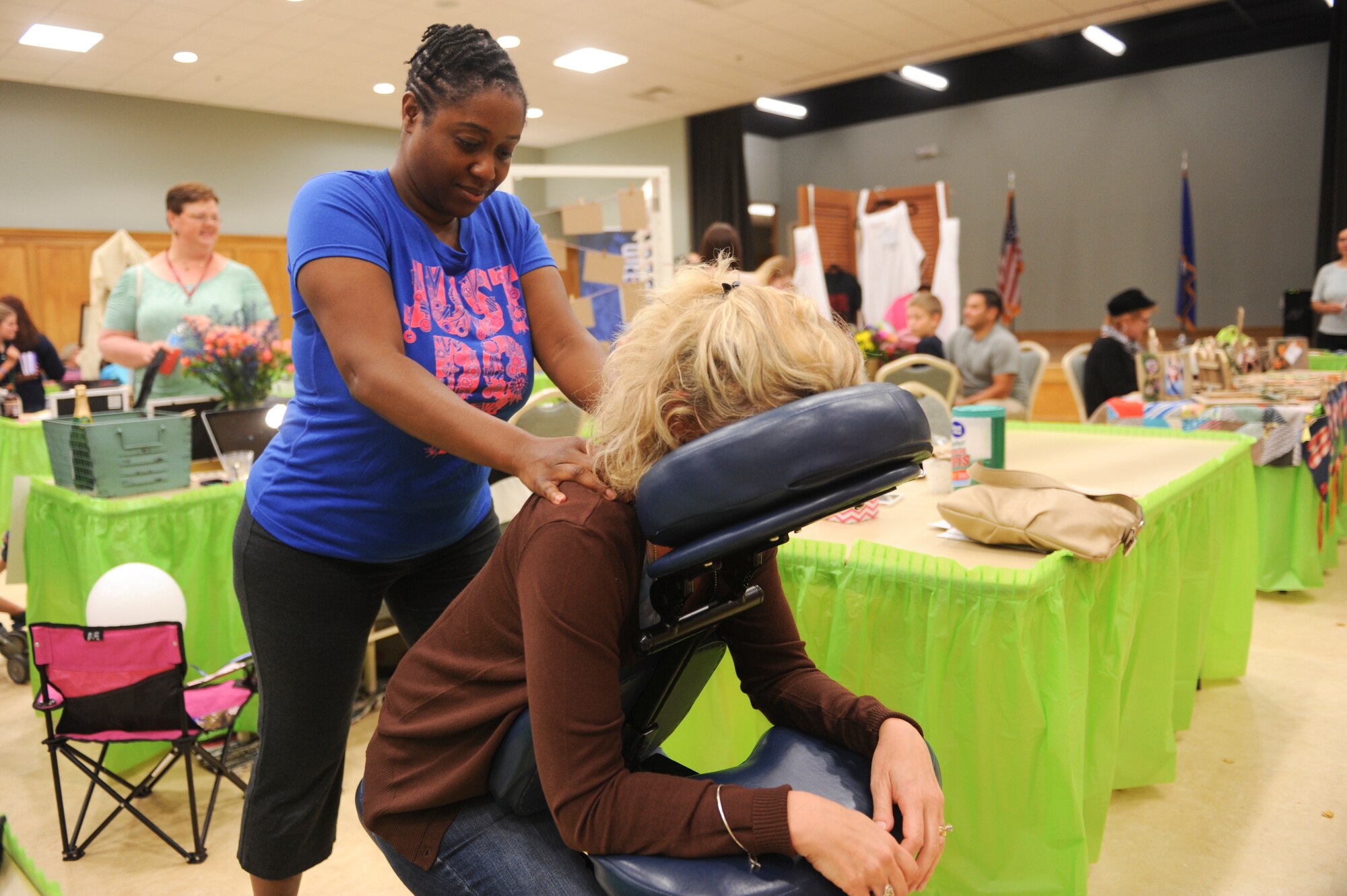 Tech. Sgt. Michelle Graba gives a chair massage to a spouse at the 2nd Annual Military  Spouse Appreciation Bazarr May 8, 2015, at Little Rock Air Force Base, Ark. Families from all branches of service, active-duty, Guard and Reserve, and retired, were welcomed to participate in the festivities. The event honored the strength, endurance and support of military spouses. (U.S. Air Force photo by Senior Airman Scott Poe)