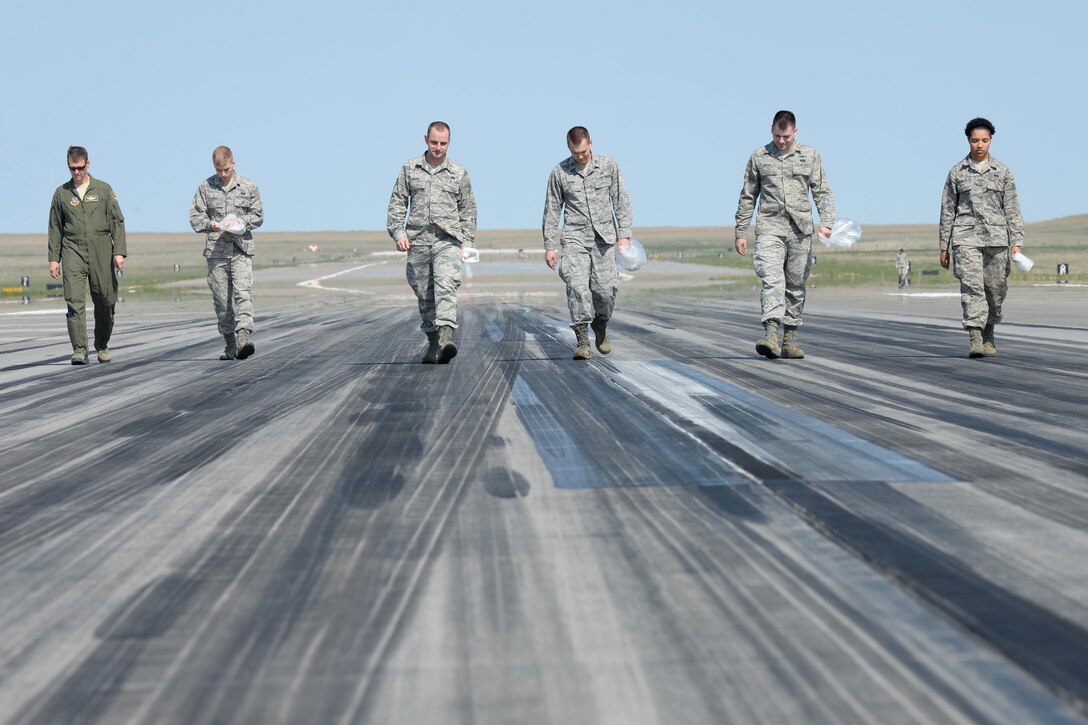 Ellsworth Airmen participate in a foreign object debris walk on the runway at Ellsworth Air Force Base, S.D., May 1, 2015. Each year, the wing conducts several FOD walks where Airmen walk the length of the flightline to remove debris and ensure safe flying operations. (U.S. Air Force photo by Airman 1st Class Rebecca Imwalle/Released)