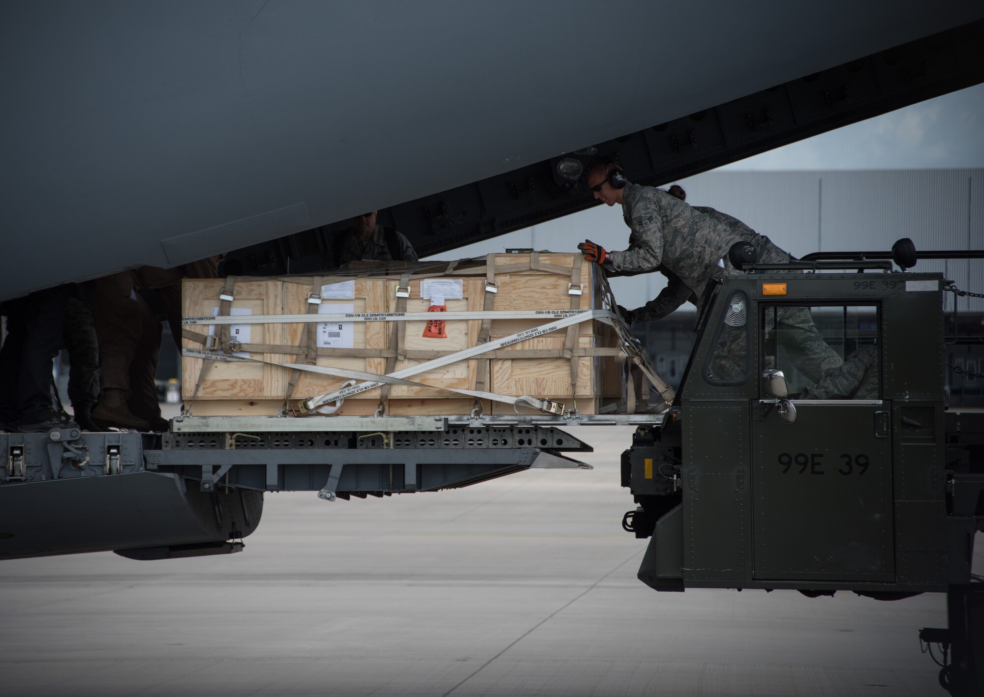 Senior Airman Sean Hastings, an air transportation specialist with the 721st Aerial Port Squadron, and Airman 1st Class Katie Kelton, an air transportation specialist with the 32nd APS, work together to push a pallet of cargo into the rear of a C-17 Globemaster III May 7, 2015, at Ramstein Air Base, Germany.  Members of the 32nd APS and the 721st APS work side-by-side for two weeks as part of total force integration training. (U.S. Air Force photo by Staff Sgt. Jonathan Hehnly)