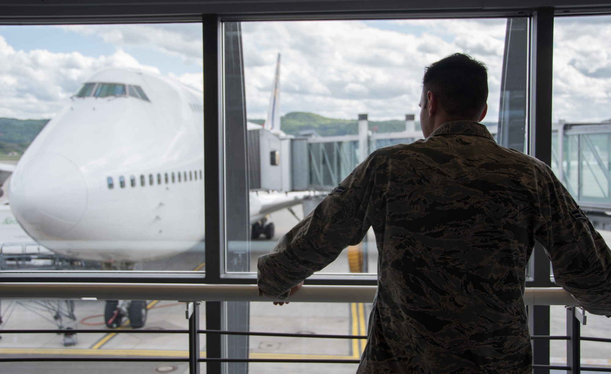 Airman 1st Class Brice Safreed, a 32nd Aerial Port Squadron passenger service specialist, looks out the window as he waits patiently for passengers to exit a 747 that landed minutes earlier May 6, 2015, at Ramstein Air Base, Germany. Working the passenger terminal here, a function not performed at Safreed’s home station, the Pittsburgh International Airport Air Reserve Station, provides passenger service personnel hands-on experience needed to handle commercial aircraft and cargo and passenger processing. (U.S. Air Force photo by Staff Sgt. Jonathan Hehnly)
