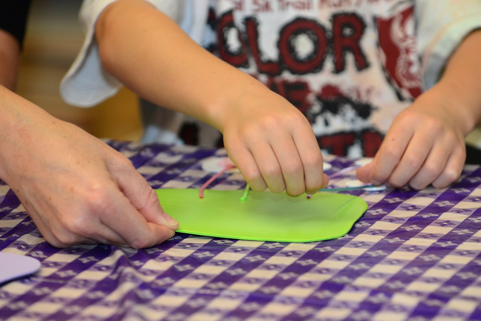 A mother helps her son making a craft during the Youth Program Mother’s Day tea May 8, 2015, at Moody Air Force Base, Ga. The crafts were a decoration reading “Sweetest Mom on Earth”. (U.S. Air Force photo by Airman 1st Class Kathleen D. Bryant)