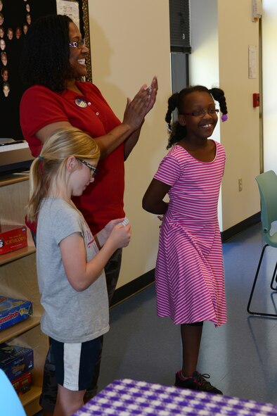 Samantha Boykins, daughter of Tech. Sgt. Christopher Boykins, left, and Alita Sorrel, daughter of Master Sgt. Tanita Sorrell, read poems to the mothers attending the Youth Program Mother’s Day tea May 8, 2015, at Moody Air Force Base, Ga. The children chose two poems that spoke of how mothers are appreciated. (U.S. Air Force photo by Airman 1st Class Kathleen D. Bryant)