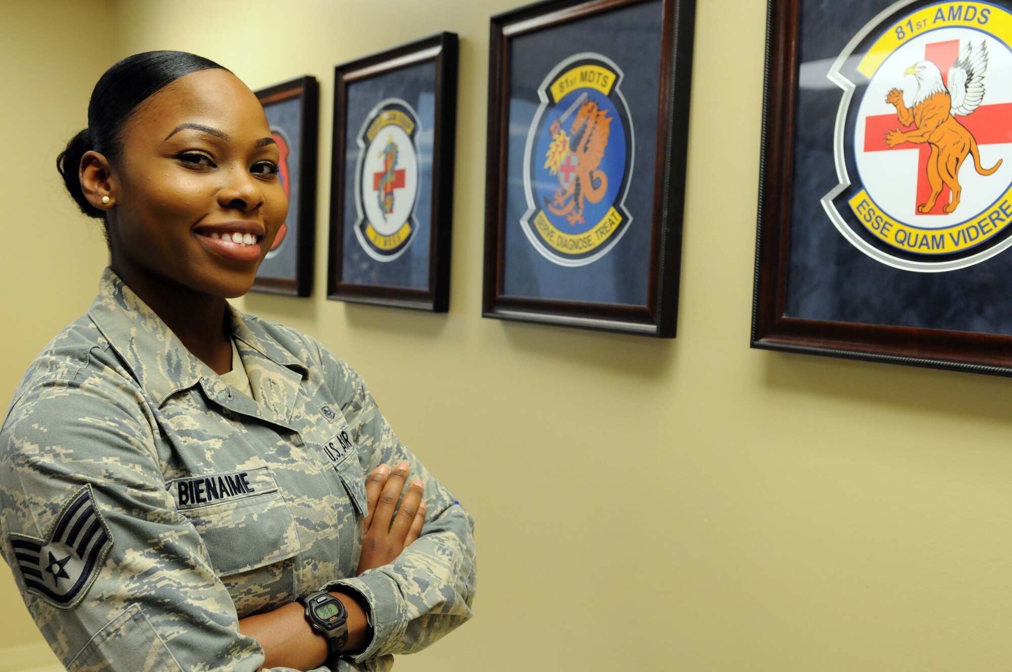 Staff Sgt. Jasmine Bienaime, an 81st Surgical Operations Squadron women’s health medical technician, poses for a photo in front of Keesler Medical Center’s squadron crests May 12, 2015, Keesler Air Force Base, Miss. Bienaime has been a member of the Air Force for almost five years and sewed on staff sergeant in April of this year. (U.S. Air Force photo by Airman 1st Class Duncan McElroy)