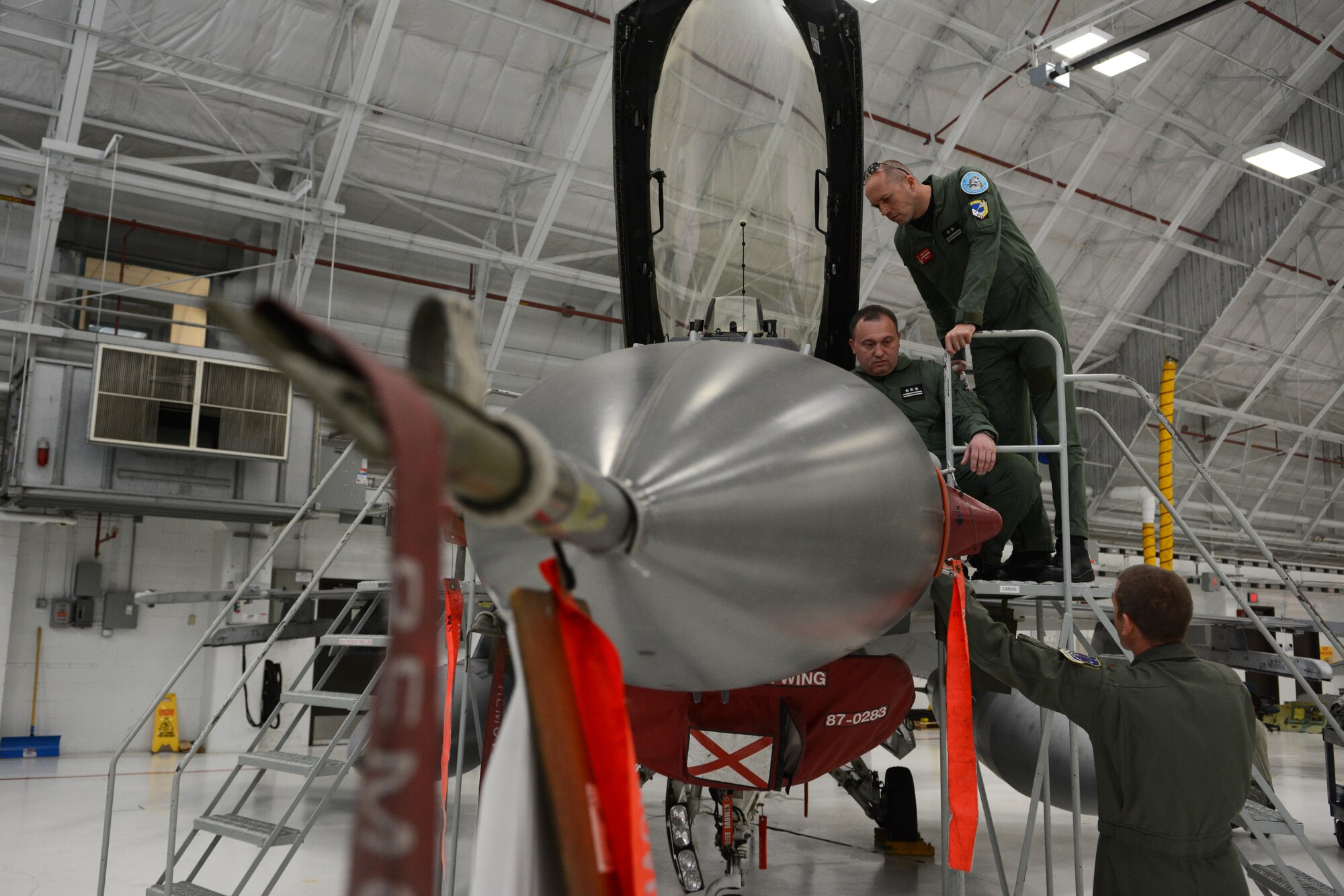 Members of the Polish Air Force spend time looking at aircraft in the phase hangar at the 115th Fighter Wing in Madison, Wis., May 4, 2015. Two pilots and three maintainers from Poland spent the week learning about the differences between their air force and the Air National Guard as a part of the State Partnership Program. (U.S. Air National Guard photo by Senior Airman Andrea F. Rhode)