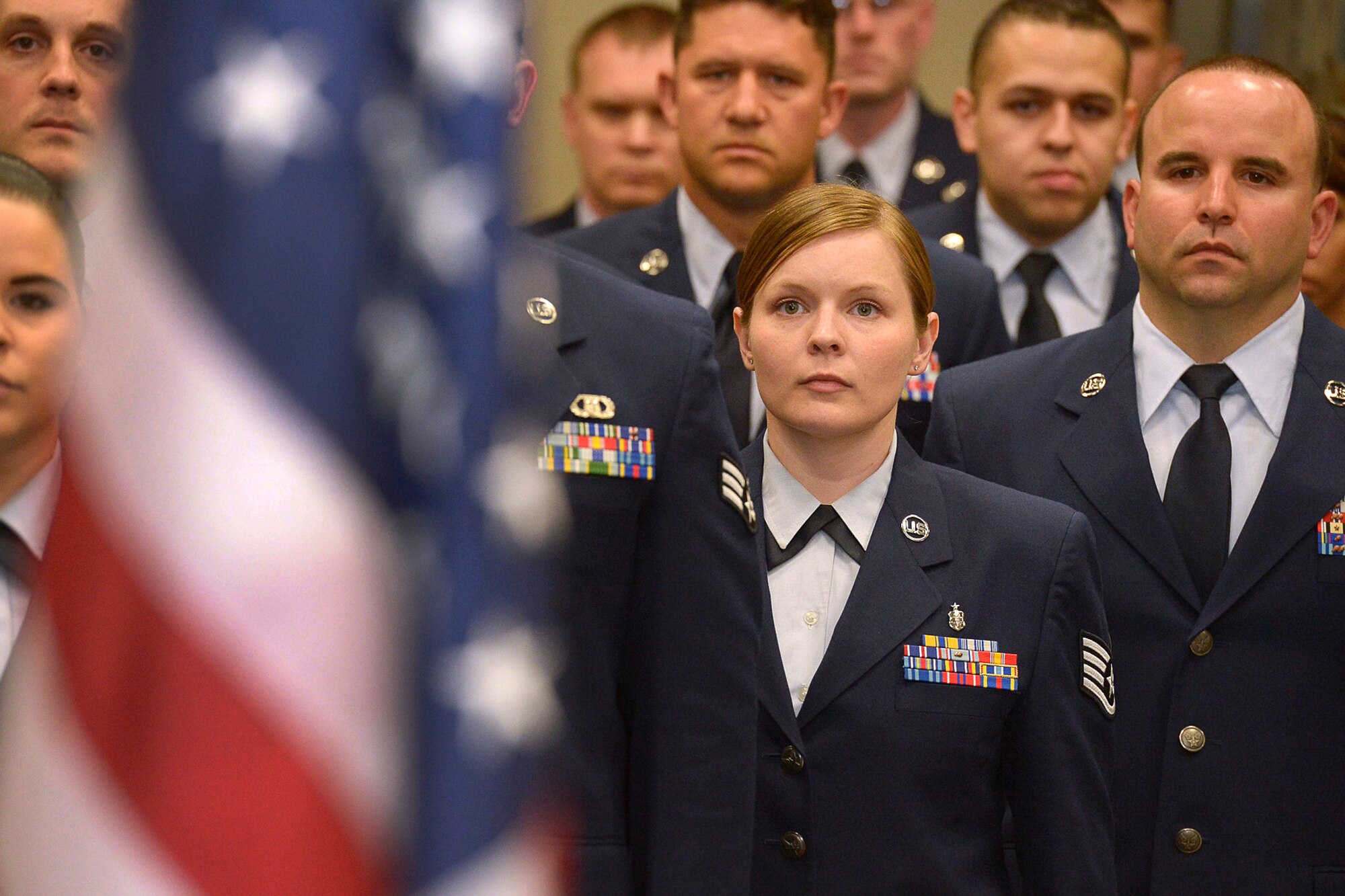 Airmen stand at attention as the national anthem is sung during the Community College of the Air Force commencement ceremony at the Hanscom Conference Center, May 8. More than 25Airmen received their degrees during the ceremony. (U.S. Air Force photo by Jerry Saslav)